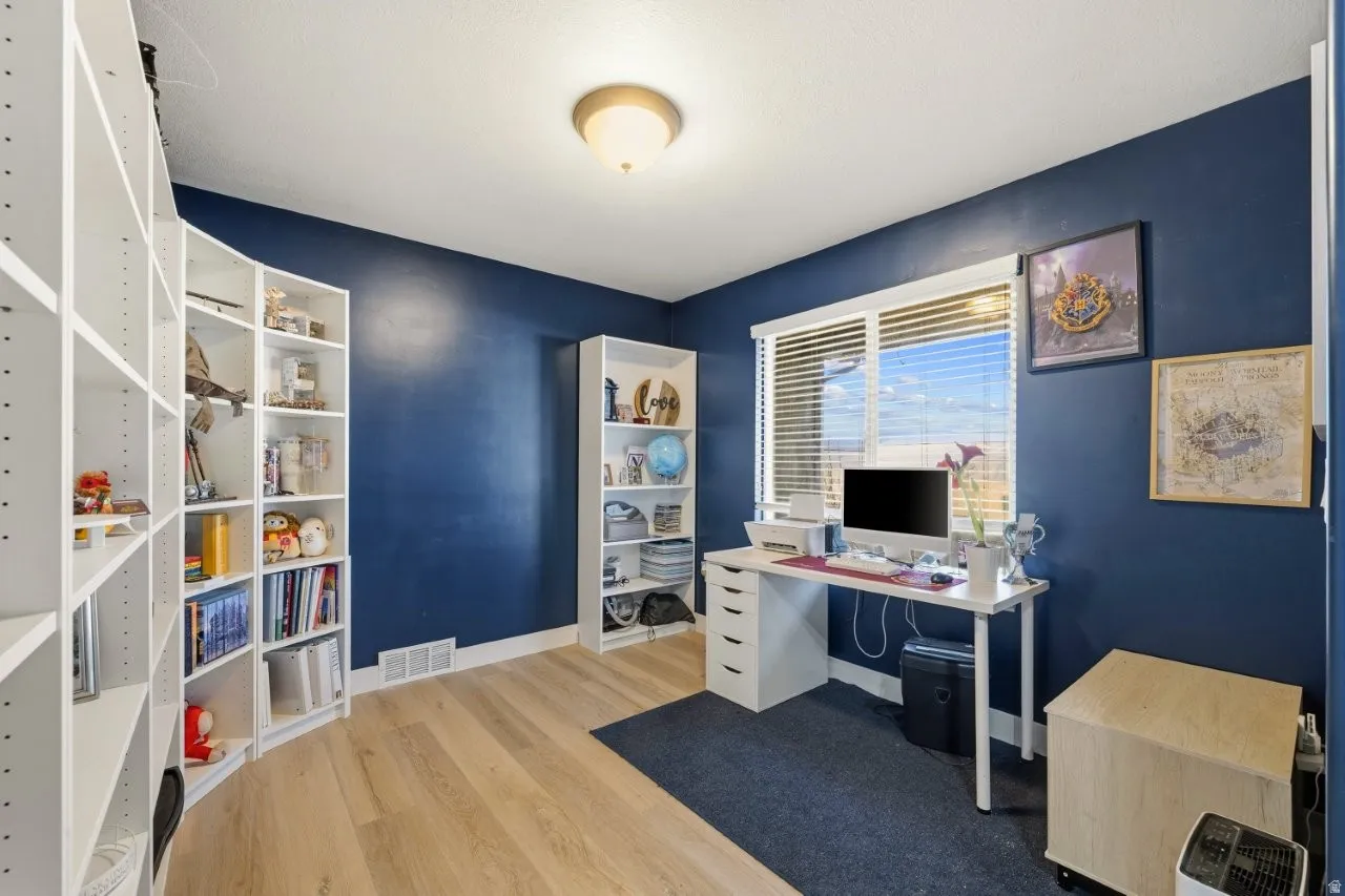 Office space with light wood-style flooring and baseboards