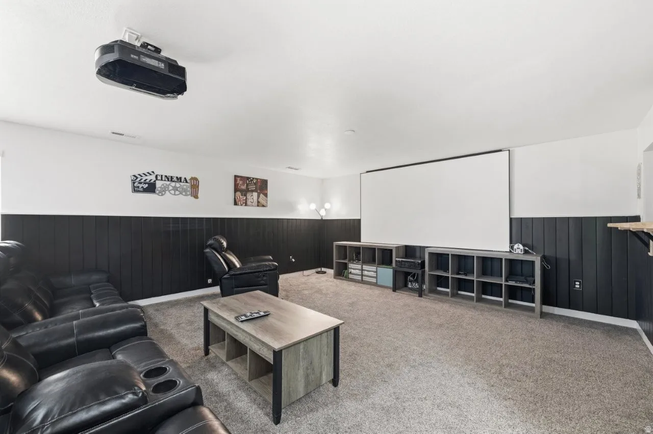 Cinema room with a wainscoted wall, wooden walls, and carpet floors