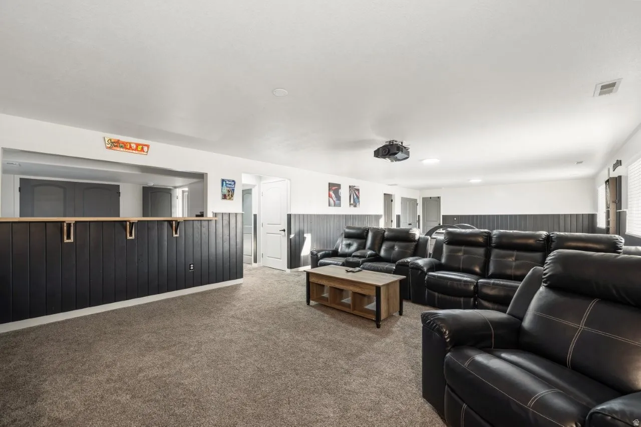 Home theater featuring wainscoting, carpet floors, and wooden walls