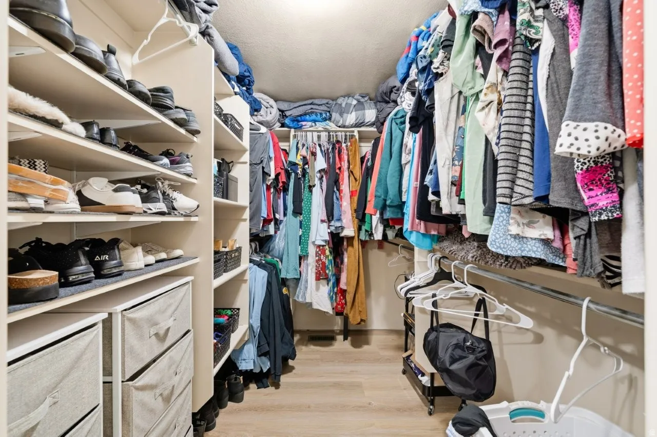 Walk in closet with light wood-type flooring