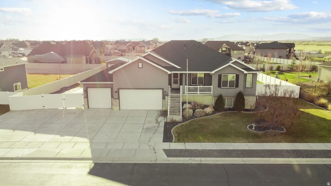 View of front of property featuring a garage, stucco siding, concrete driveway, and stone siding