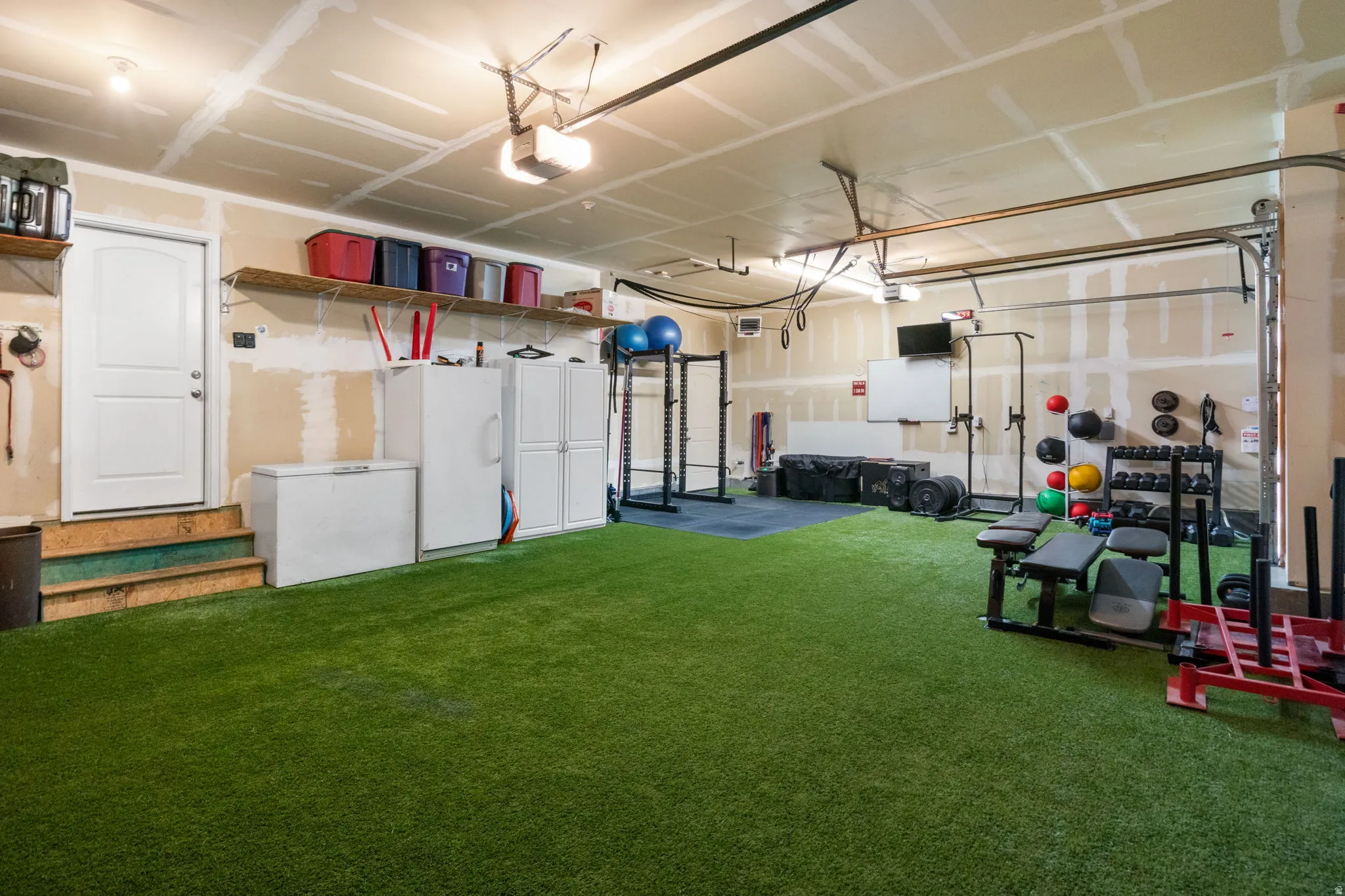 Garage featuring freestanding refrigerator and a garage door opener