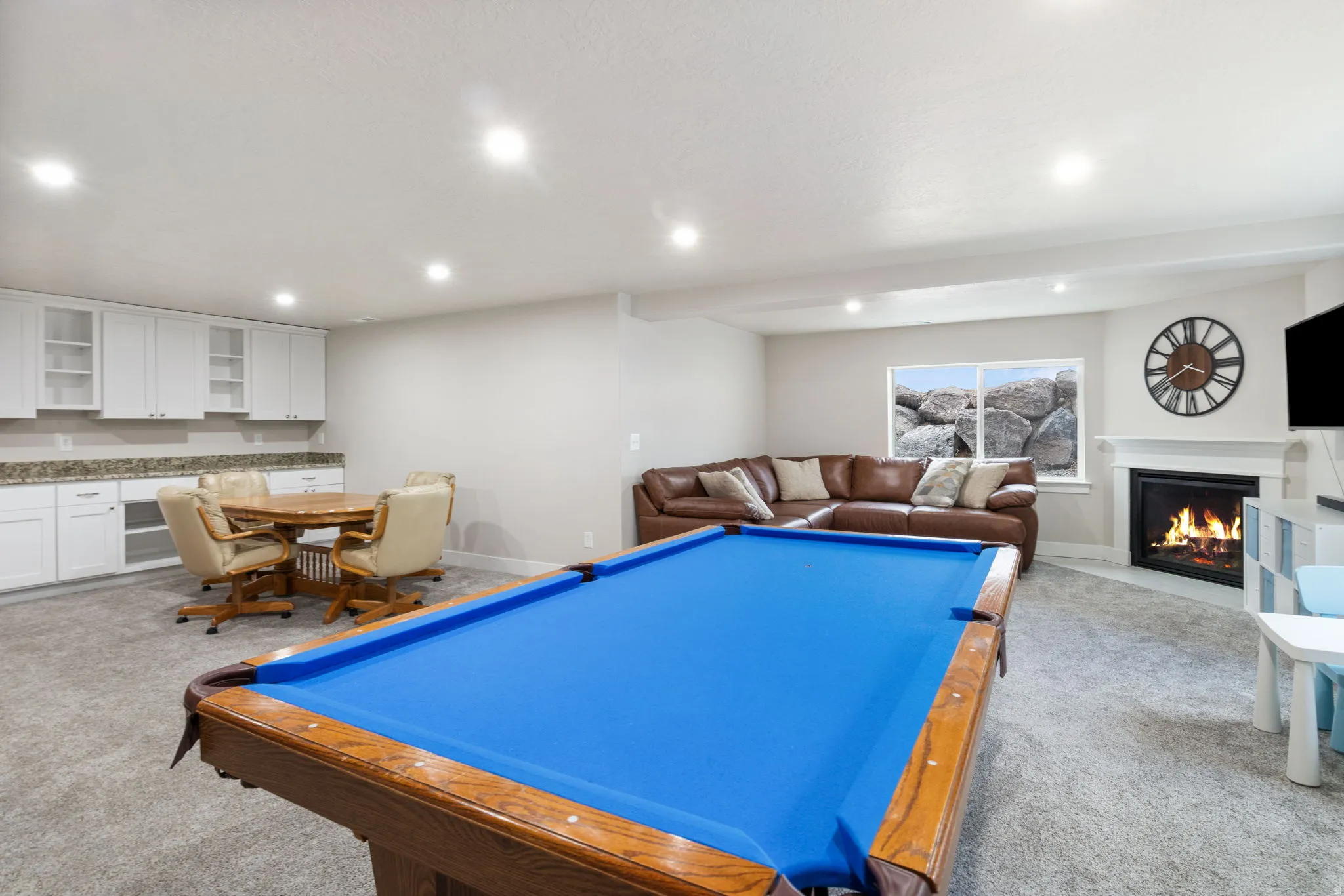 Rec room featuring a fireplace with flush hearth, light colored carpet, and recessed lighting