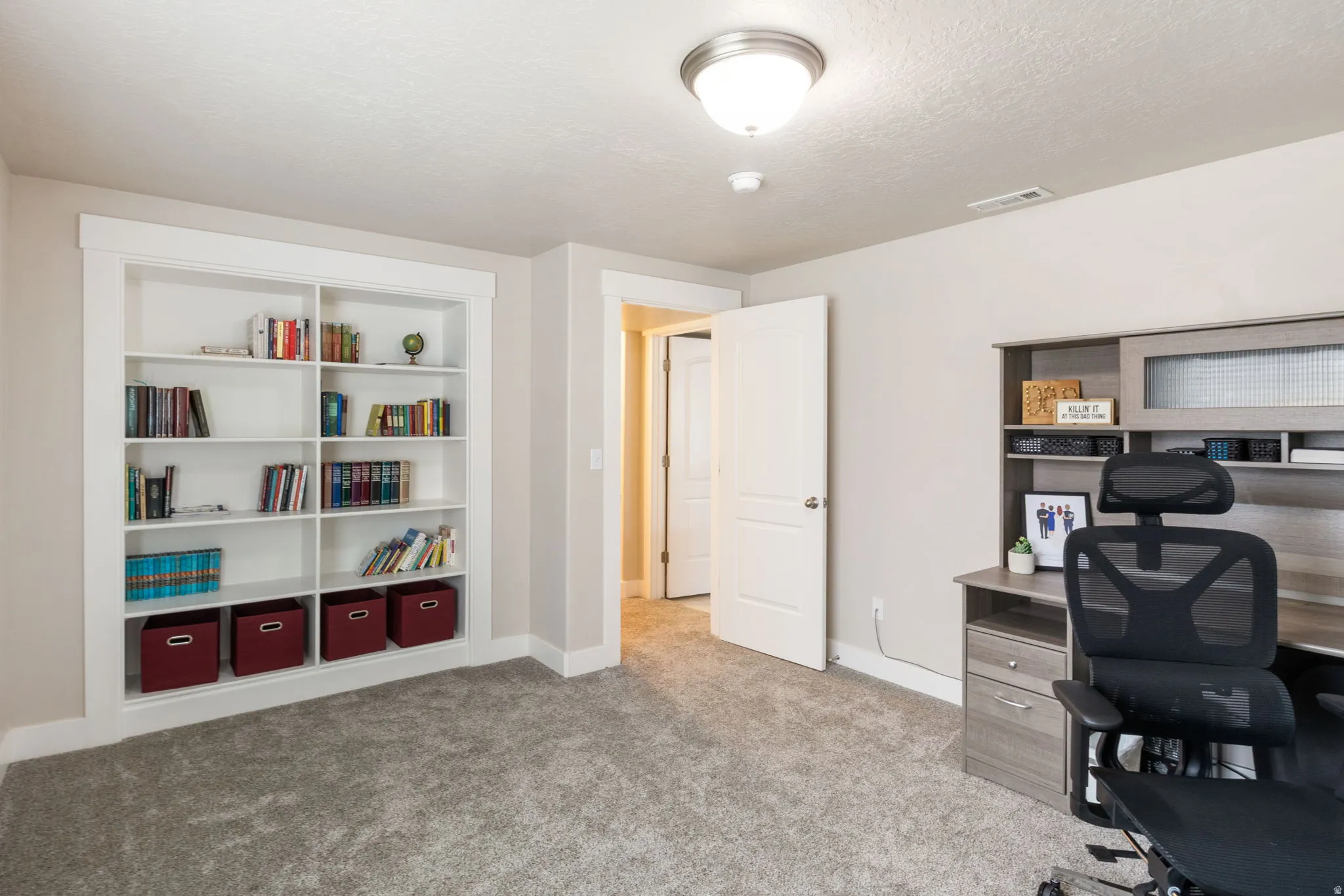 Office featuring built in features, light carpet, and a textured ceiling