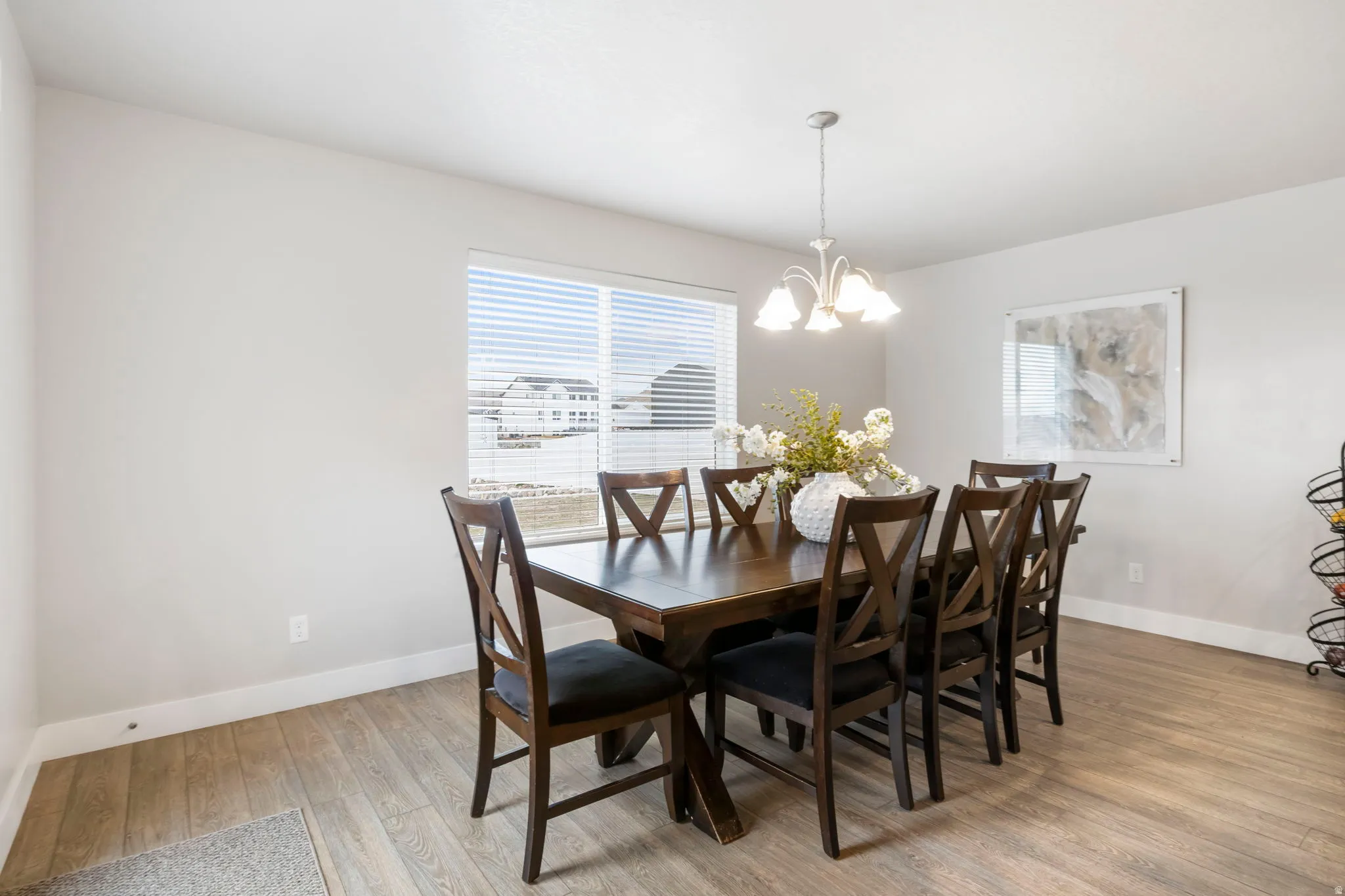 Dining space with light wood finished floors and hanging lights