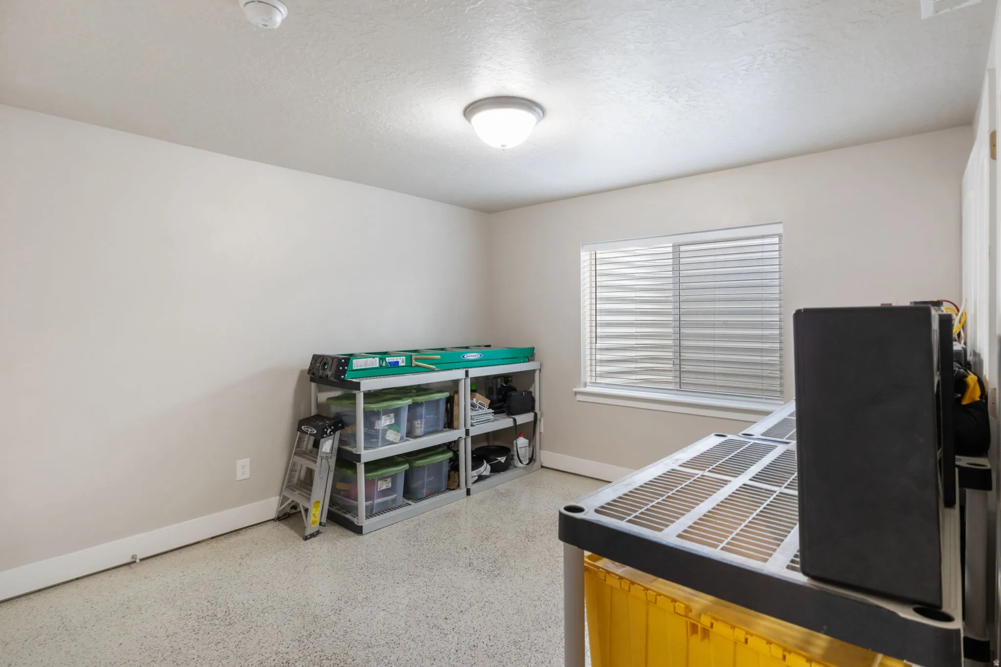 Bedroom featuring dark speckled floor and a textured ceiling