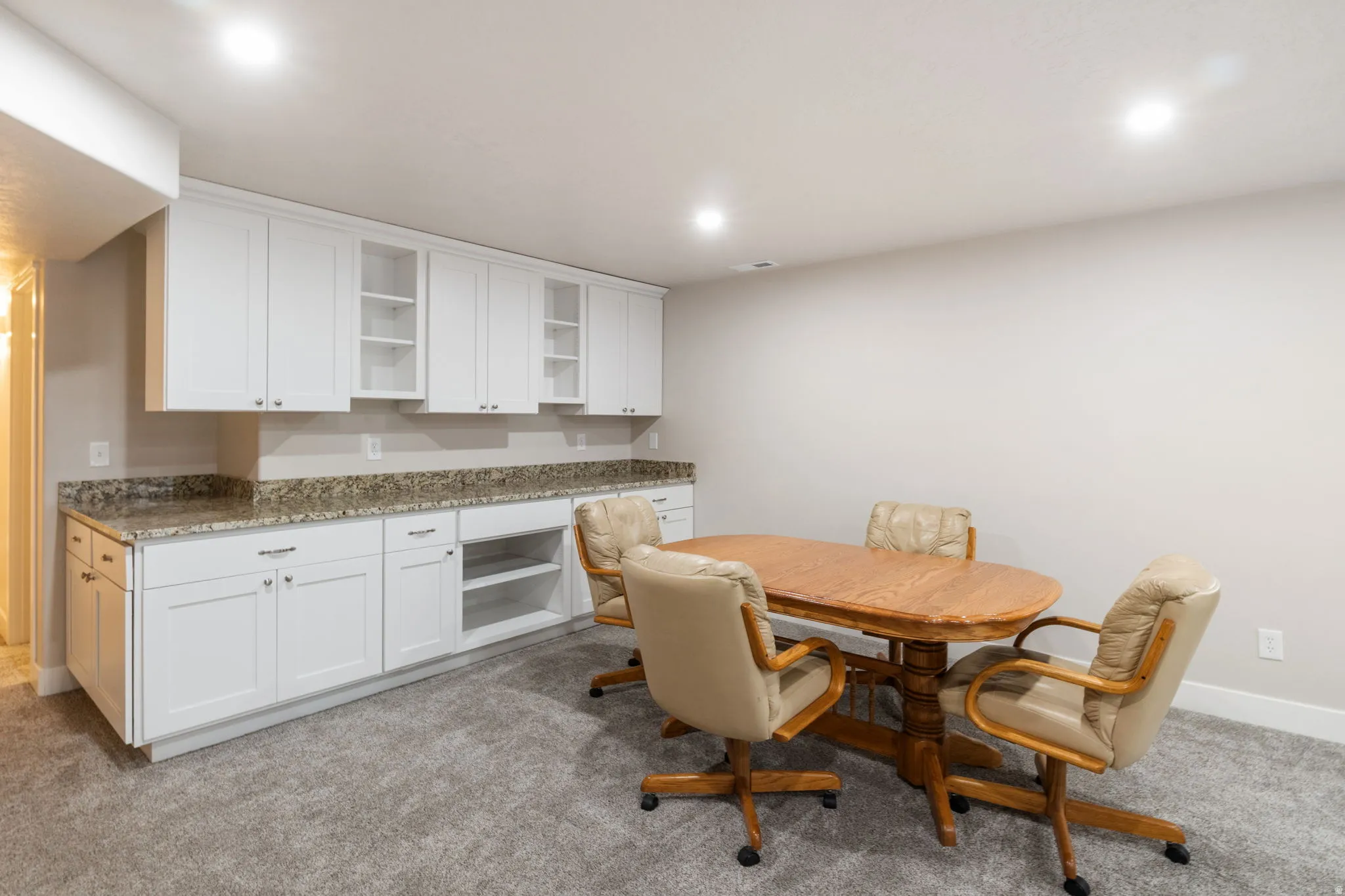 Dining space with light carpet and recessed lighting