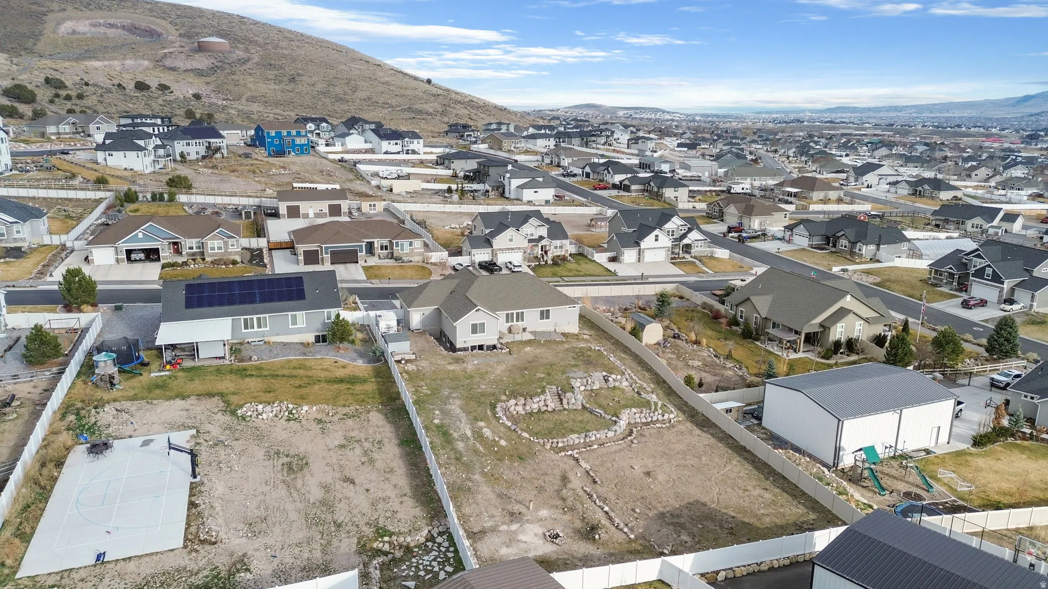Aerial view of property and surrounding area with mountains and nearby suburban area