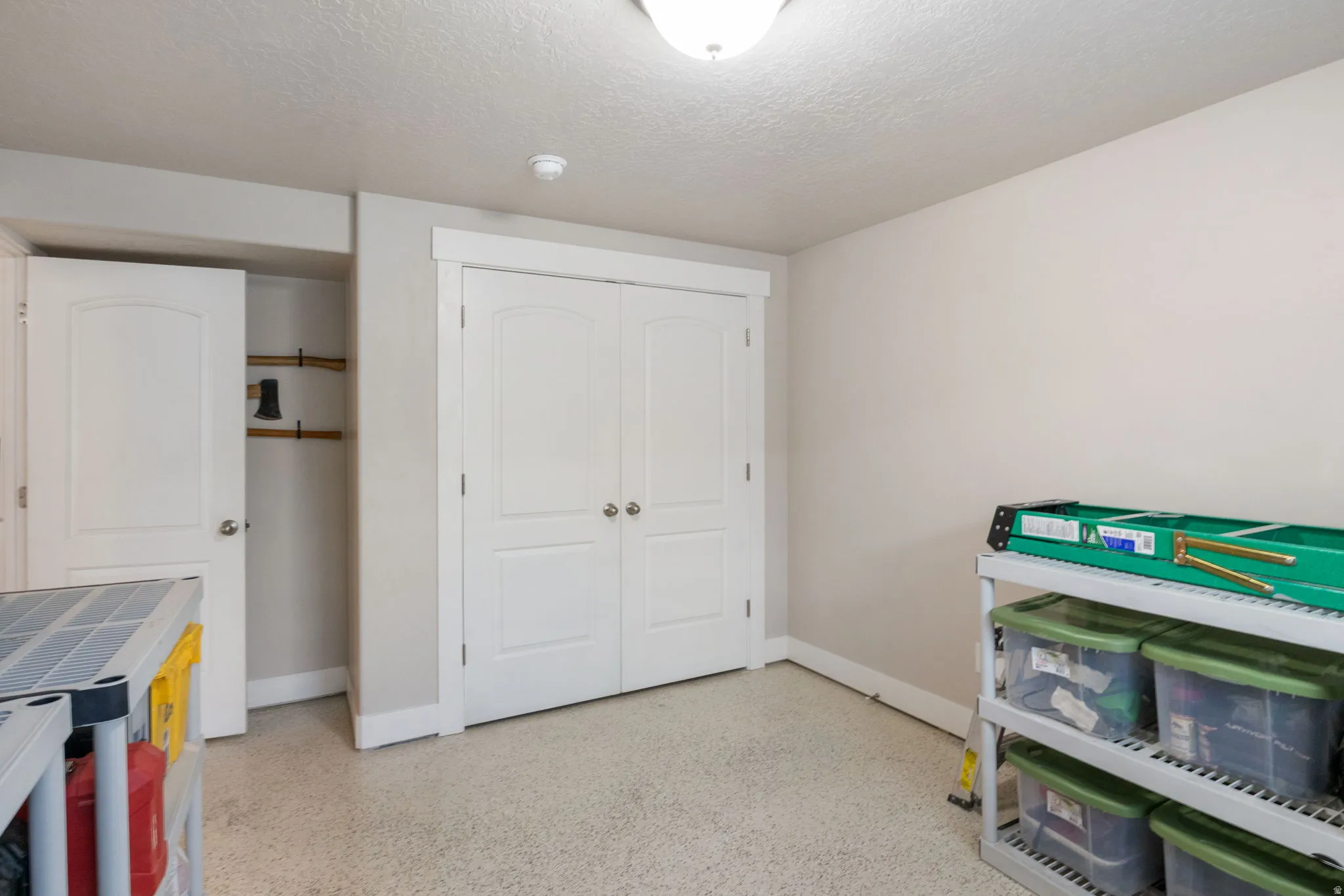 Game room featuring a textured ceiling and dark aggregate flooring