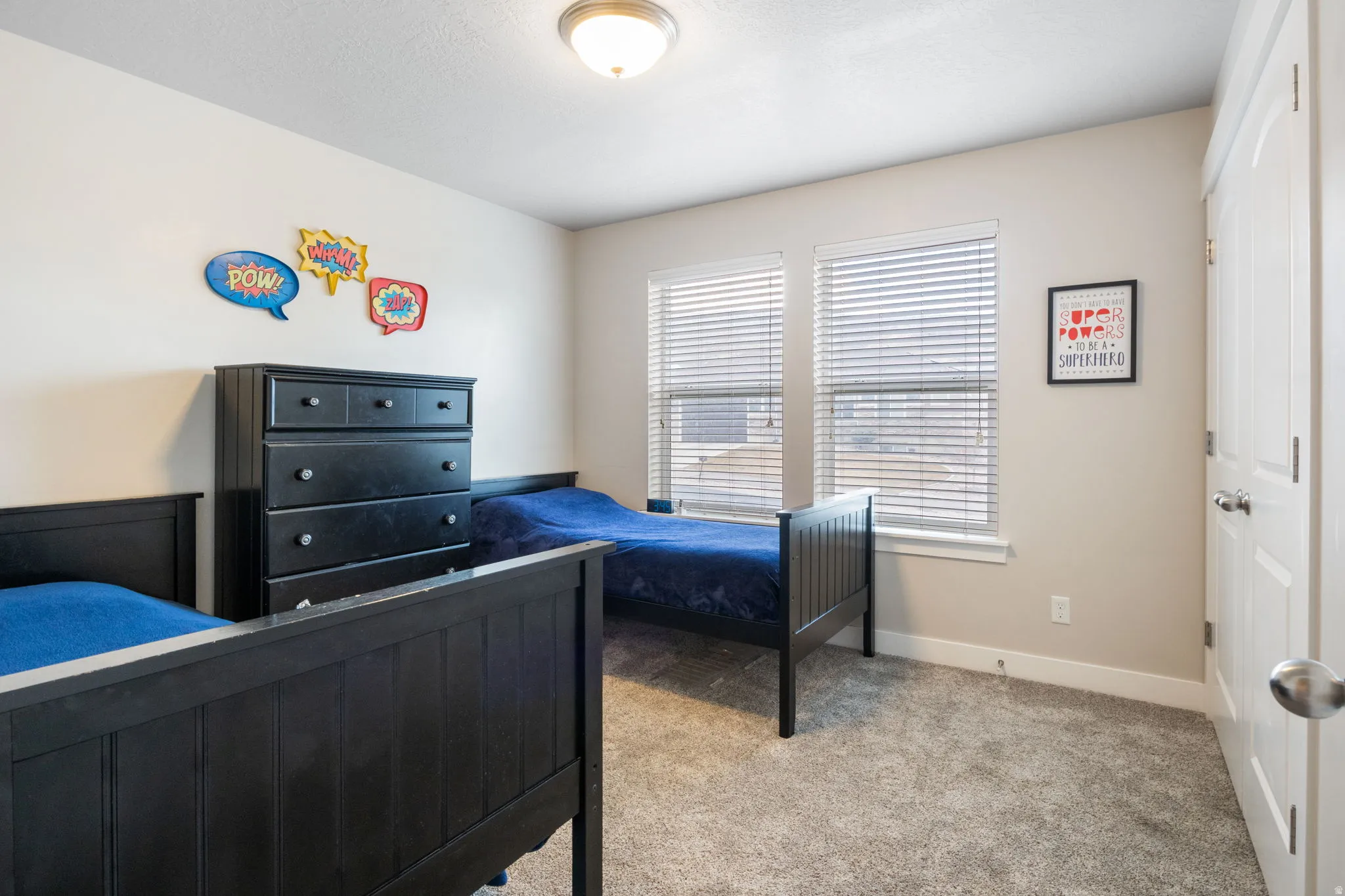 Bedroom with light colored carpet and baseboards