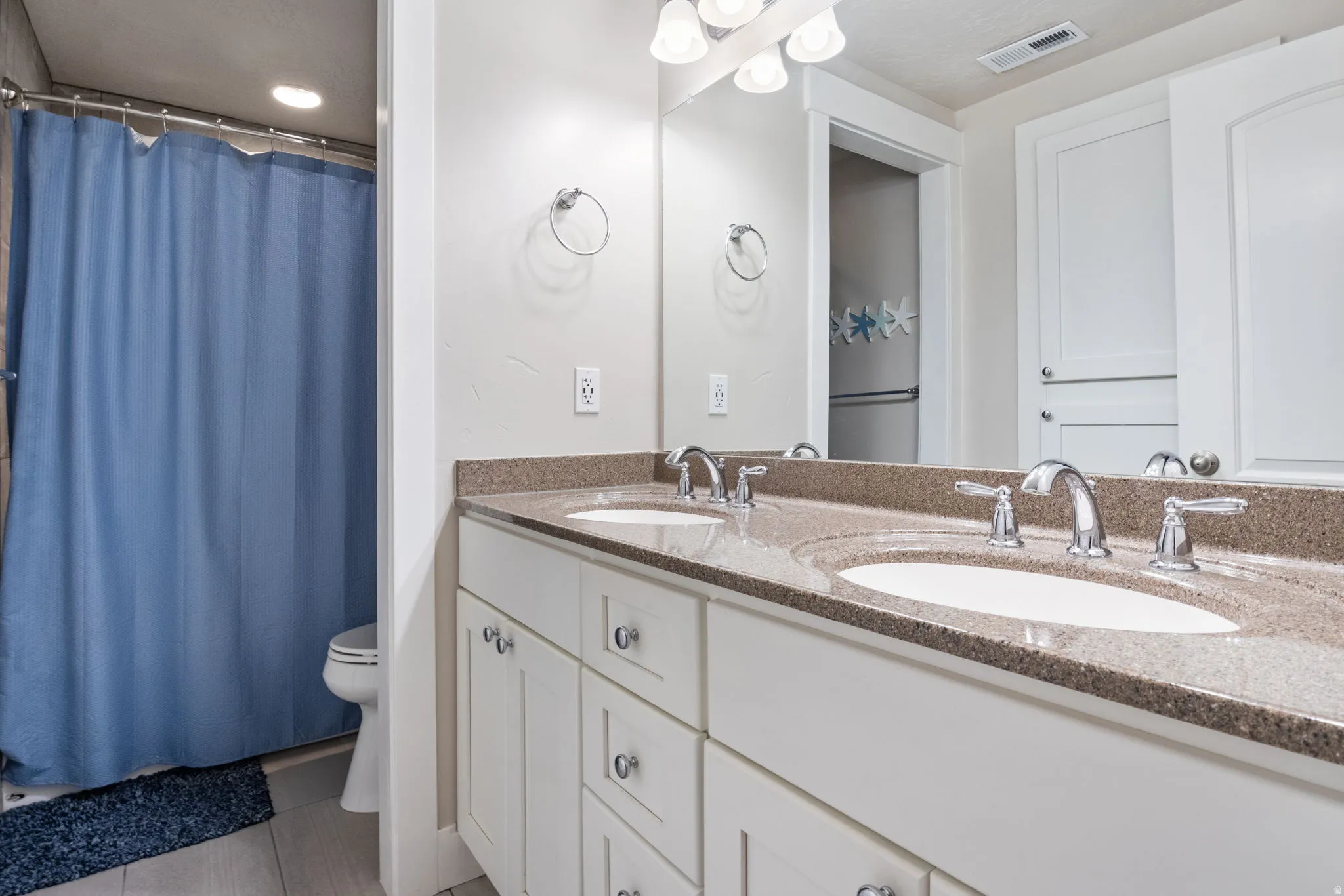 Full bathroom with double vanity and light tile patterned flooring