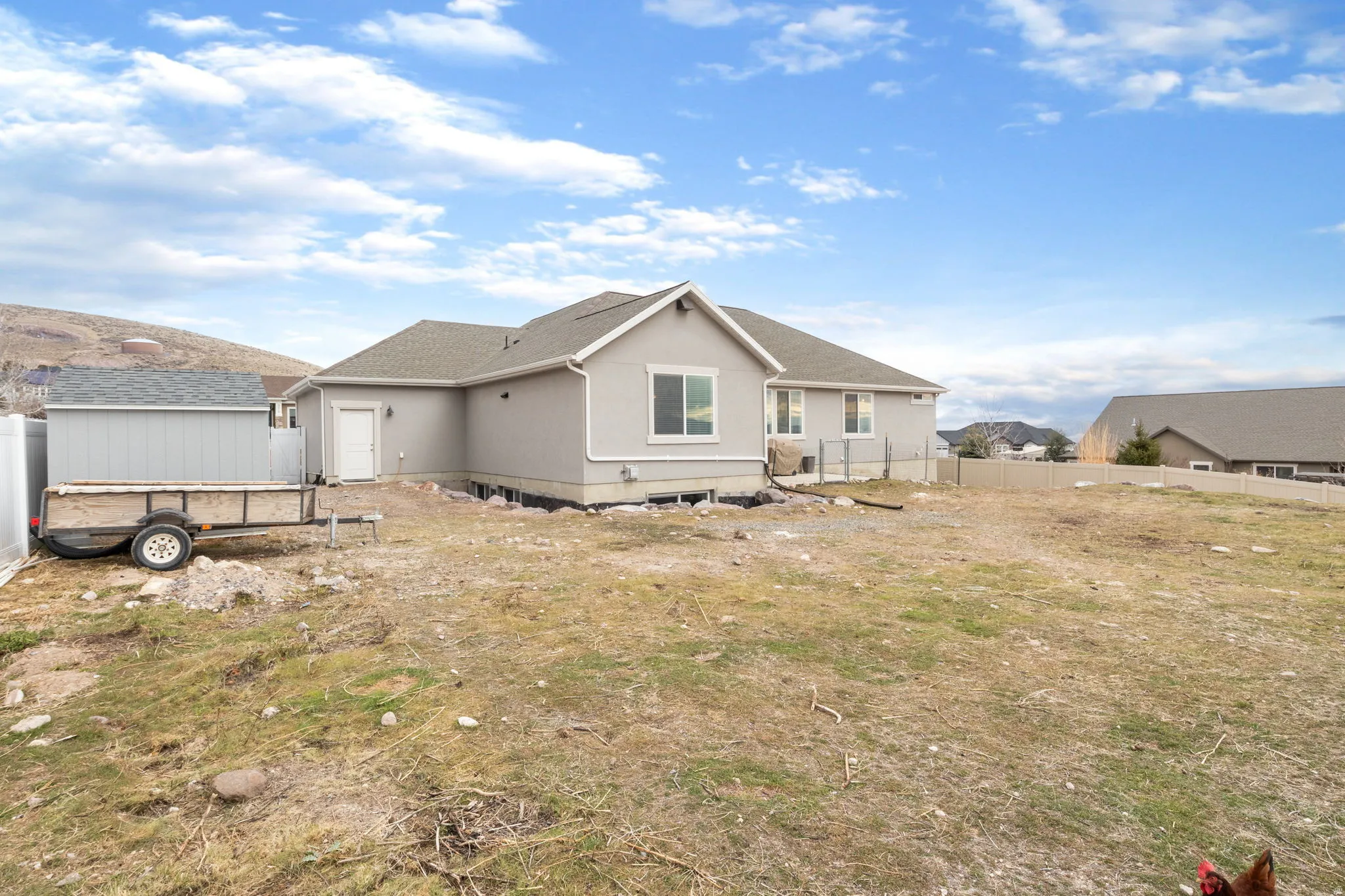 Rear view of house with a fenced backyard and stucco siding