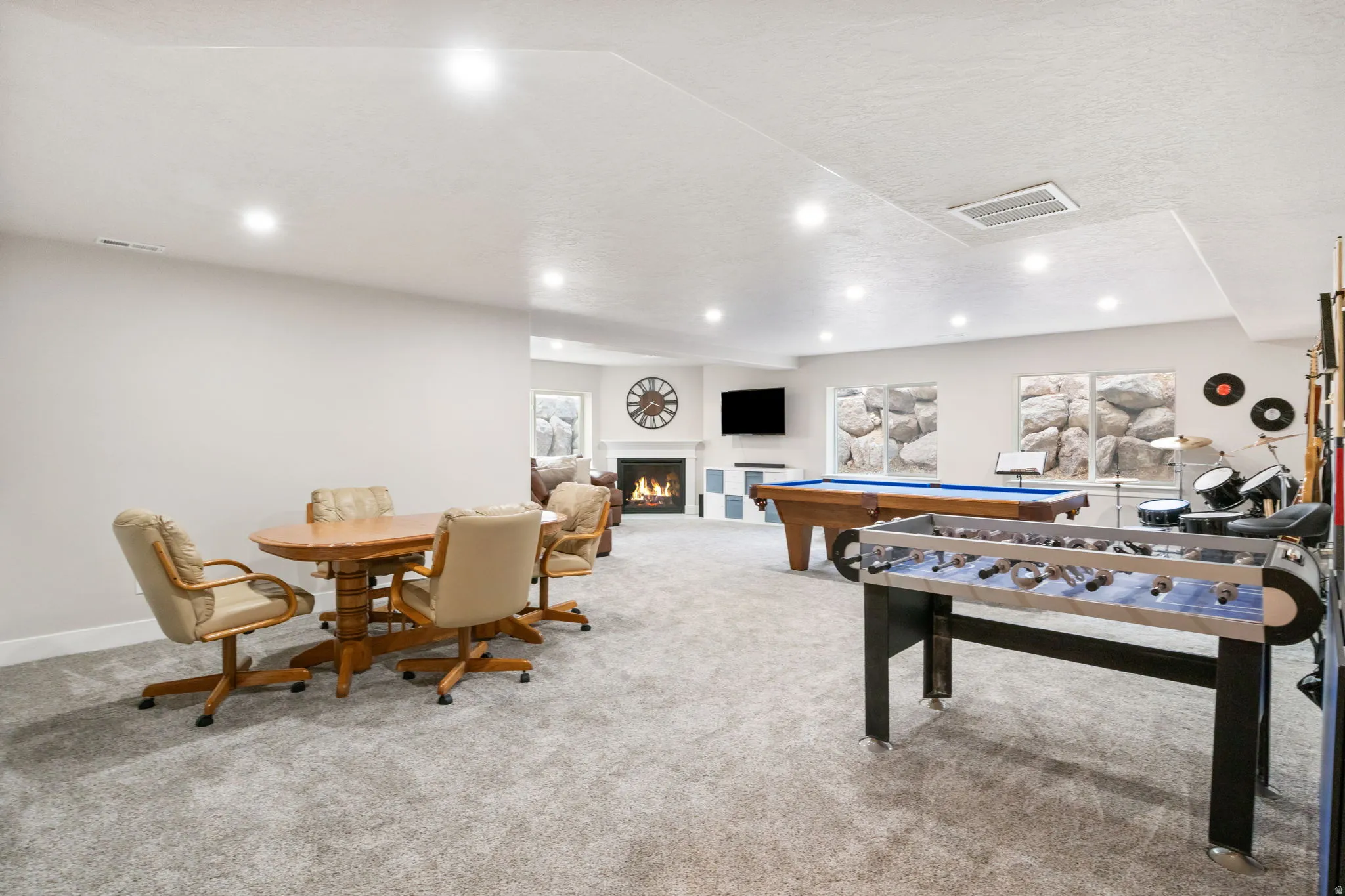 Recreation room with a warm lit fireplace, pool table, a textured ceiling, and recessed lighting