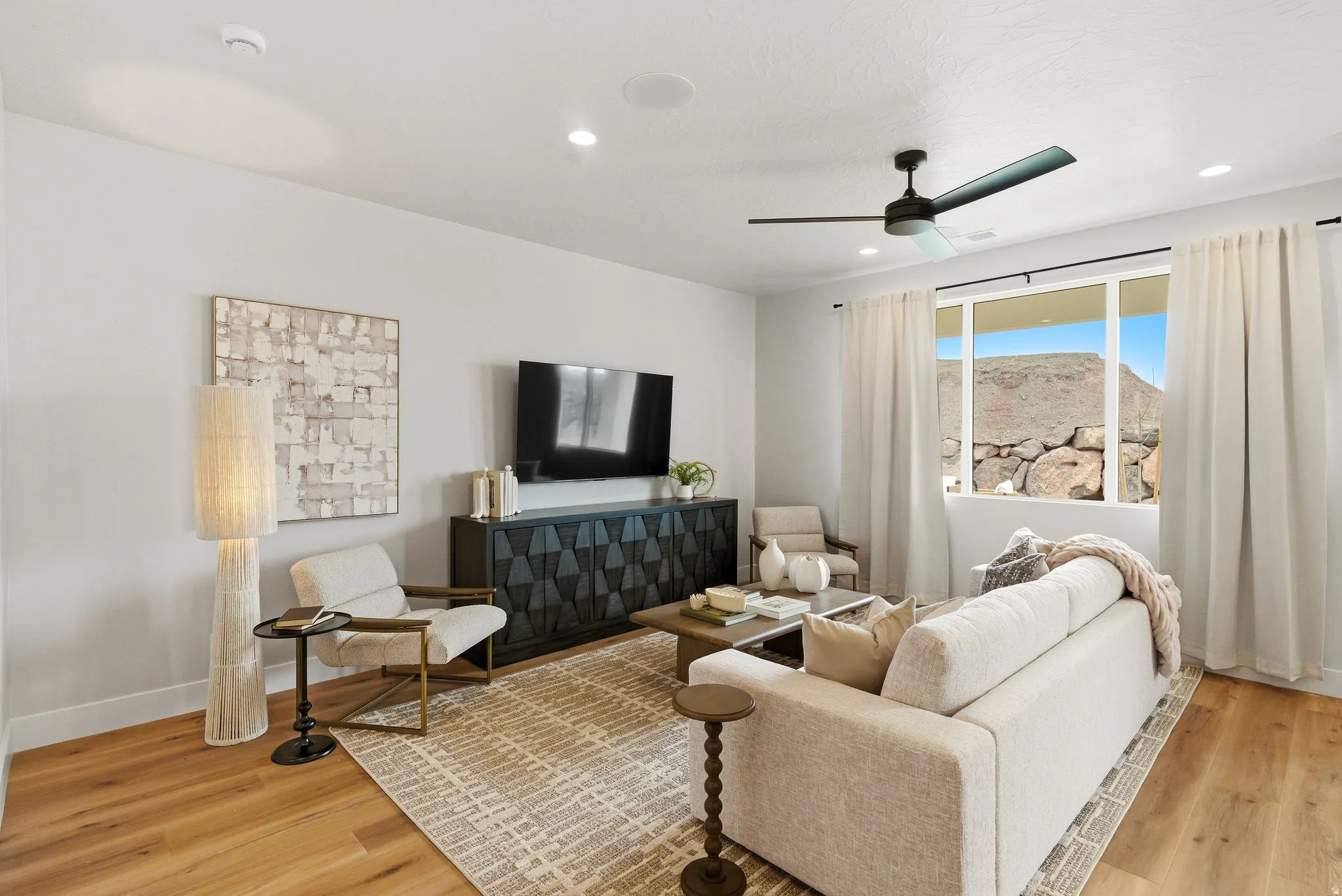 Living room with light wood finished floors, a ceiling fan, and recessed lighting