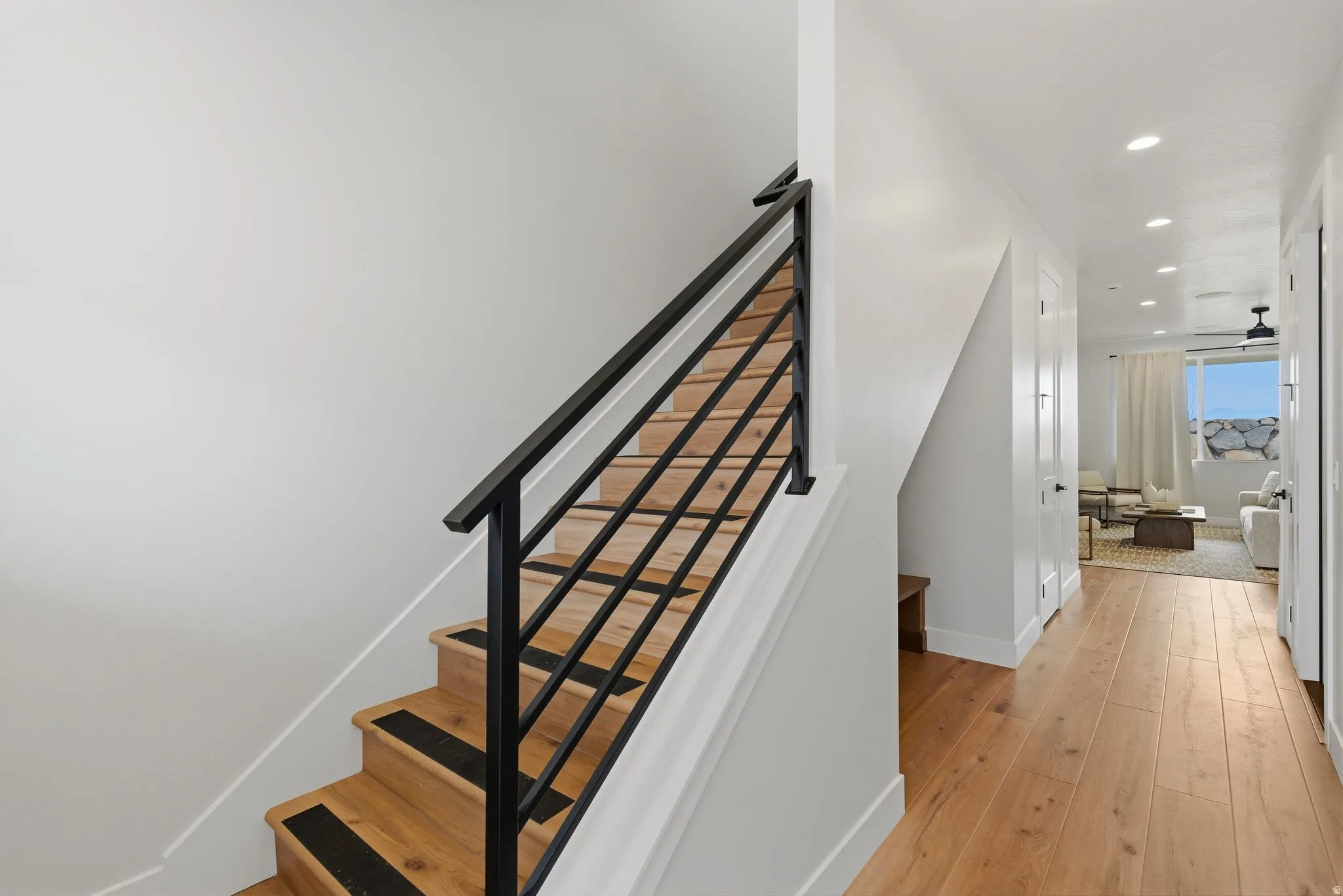 Staircase with hardwood / wood-style floors and recessed lighting