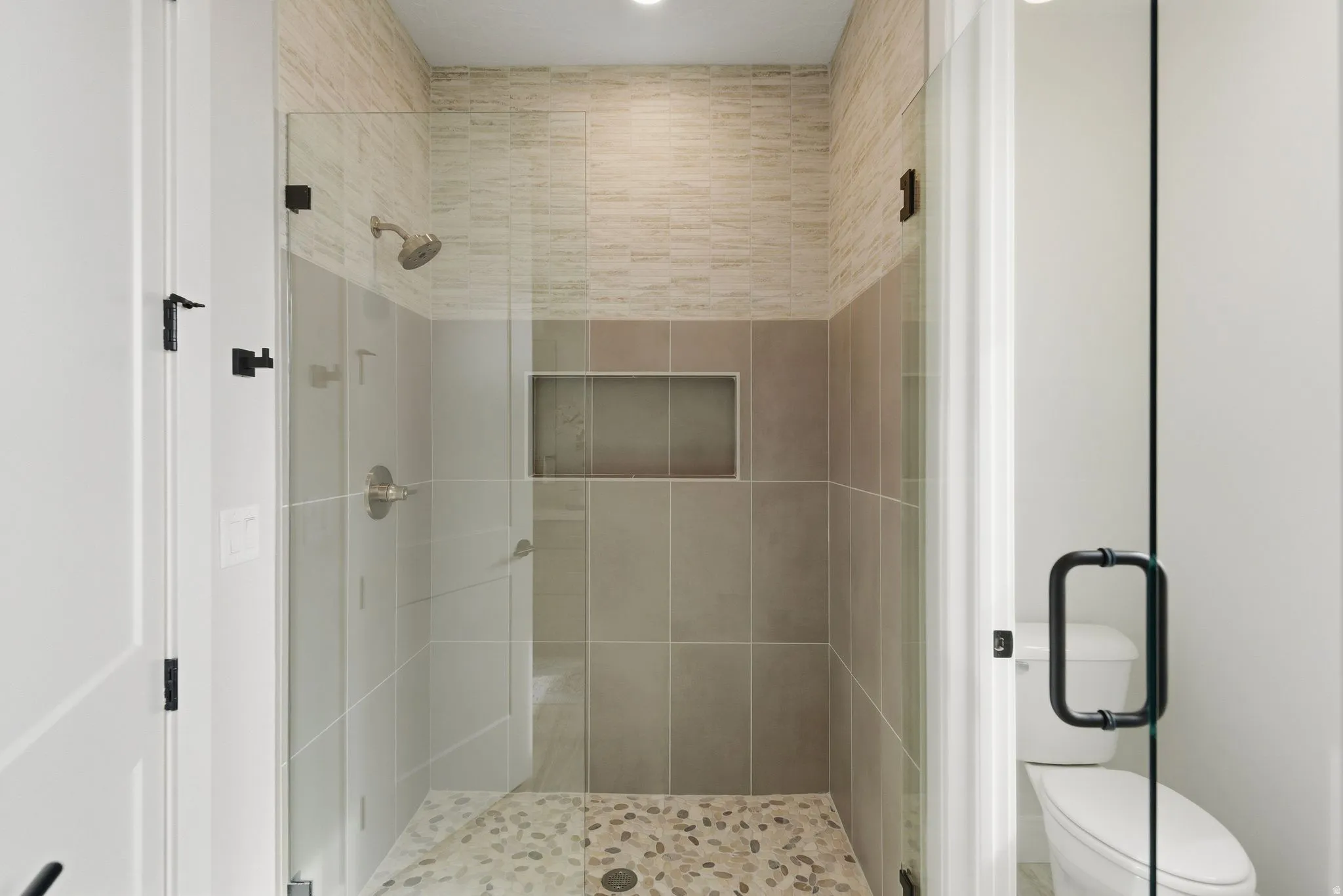 Full bath featuring a stall shower and toilet