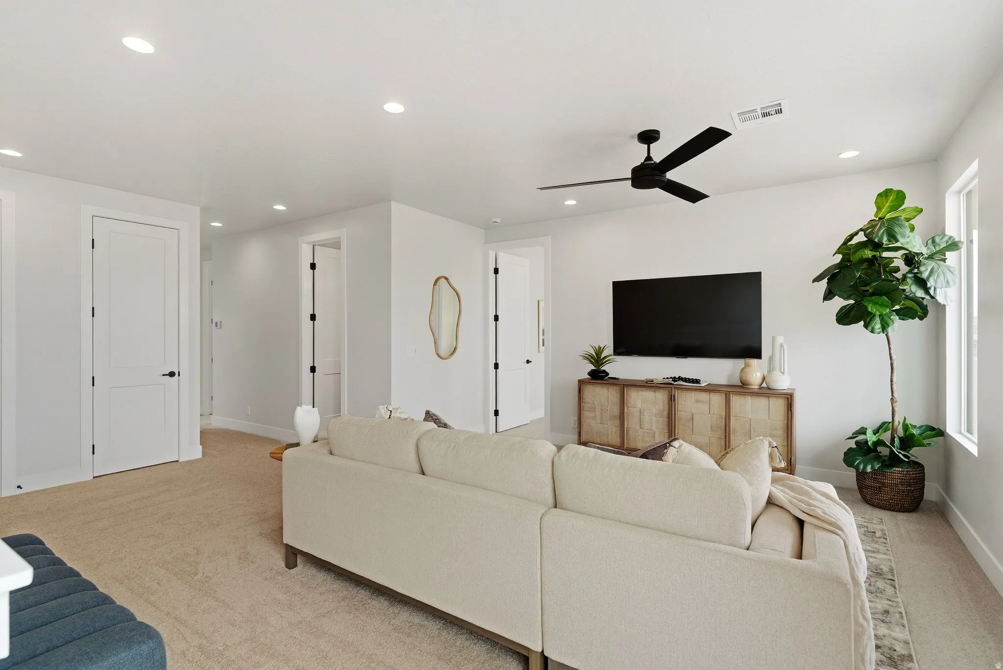 Living room with light carpet, ceiling fan, and recessed lighting