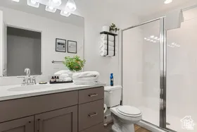 Bathroom featuring a shower stall, vanity, and dark wood finished floors