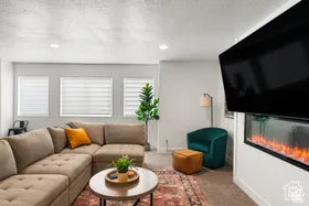 Living room featuring carpet, a textured ceiling, recessed lighting, and a glass covered fireplace