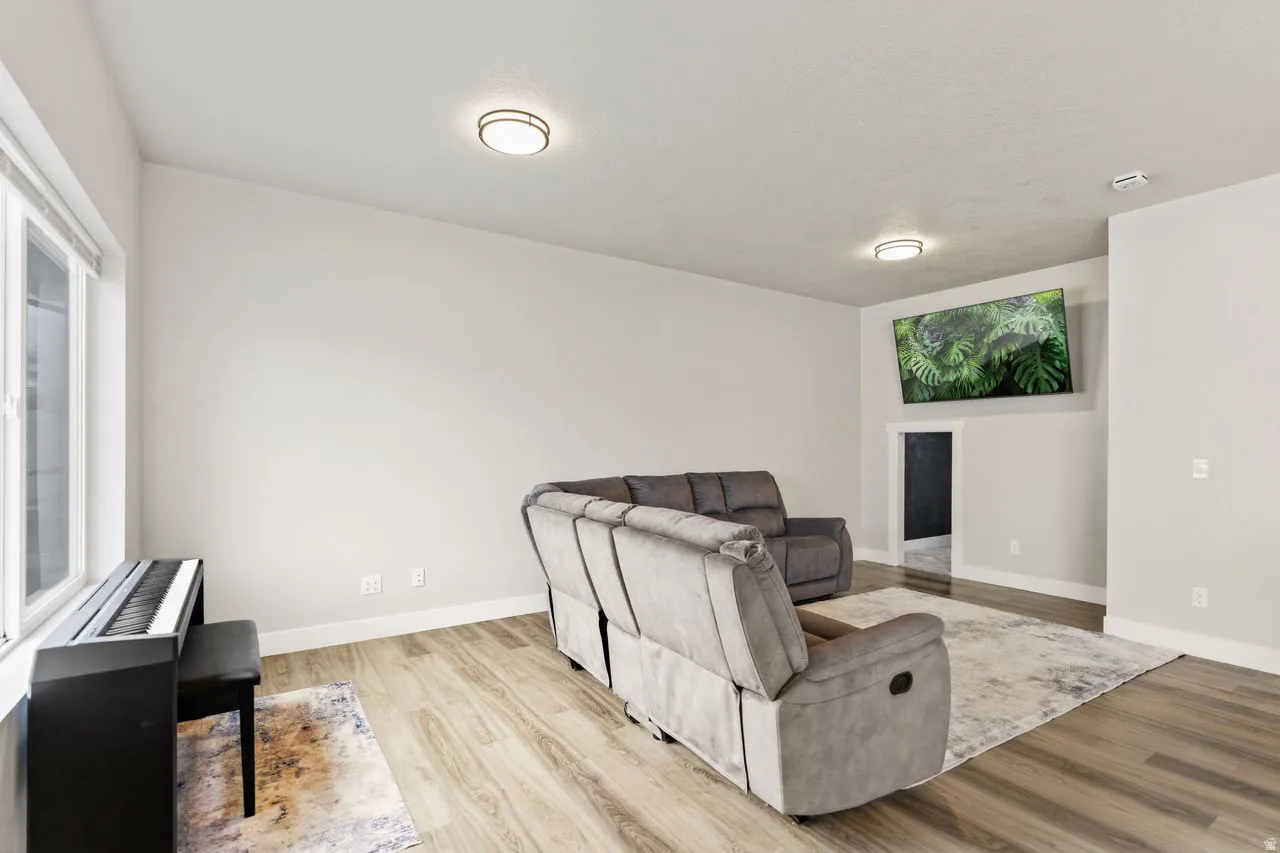 Large family room with wood-style flooring and a large window for tons of natural light
