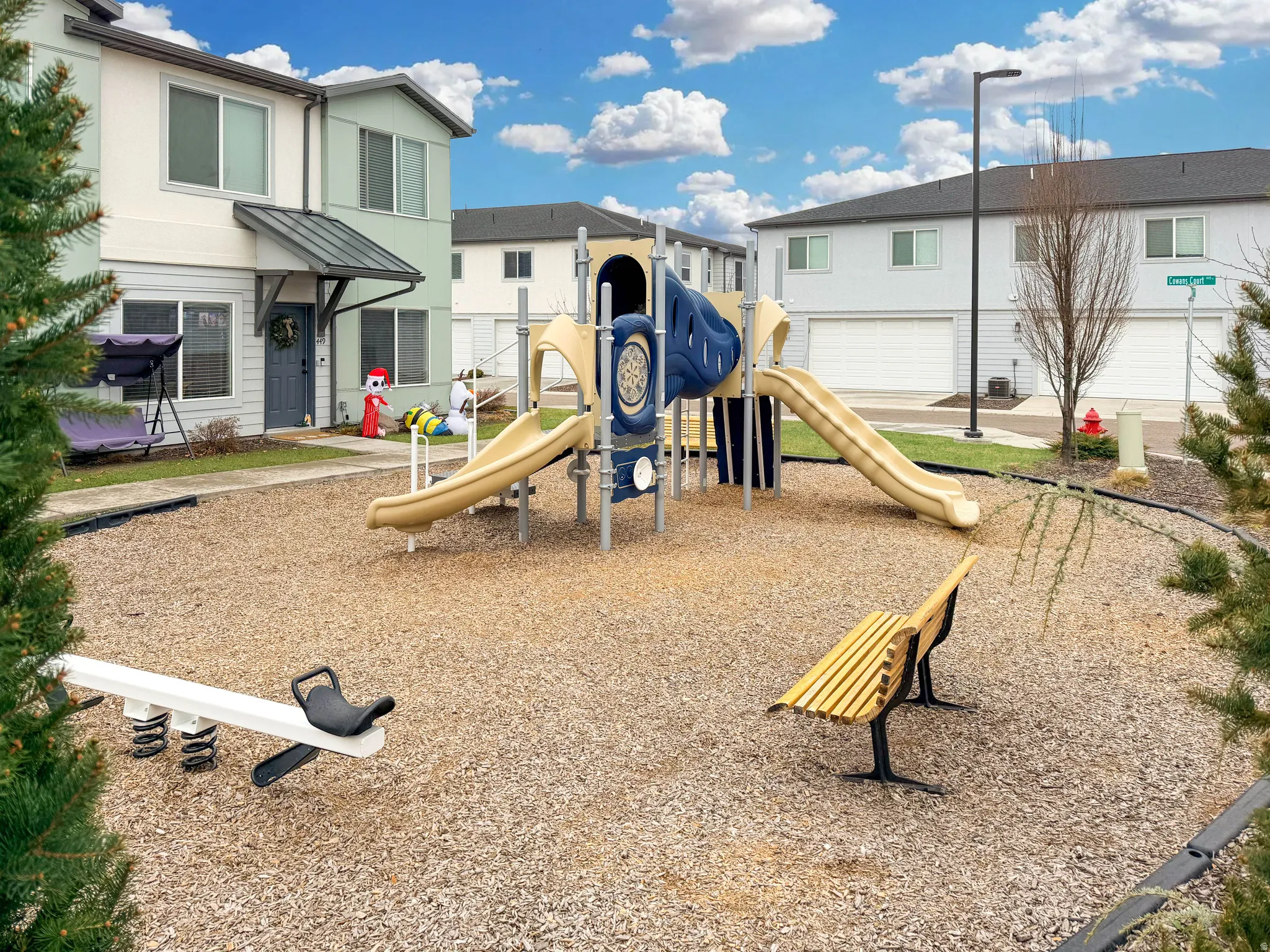 Community playground with tot lot, slides, climbing wall and bench