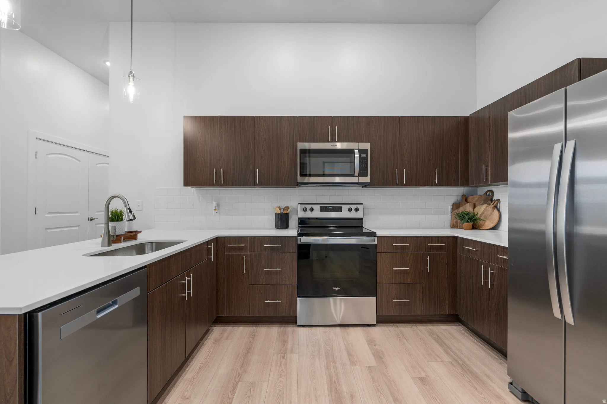 Modern kitchen with dark wood tone cabinets and elevated finishes. *Fridge not included.