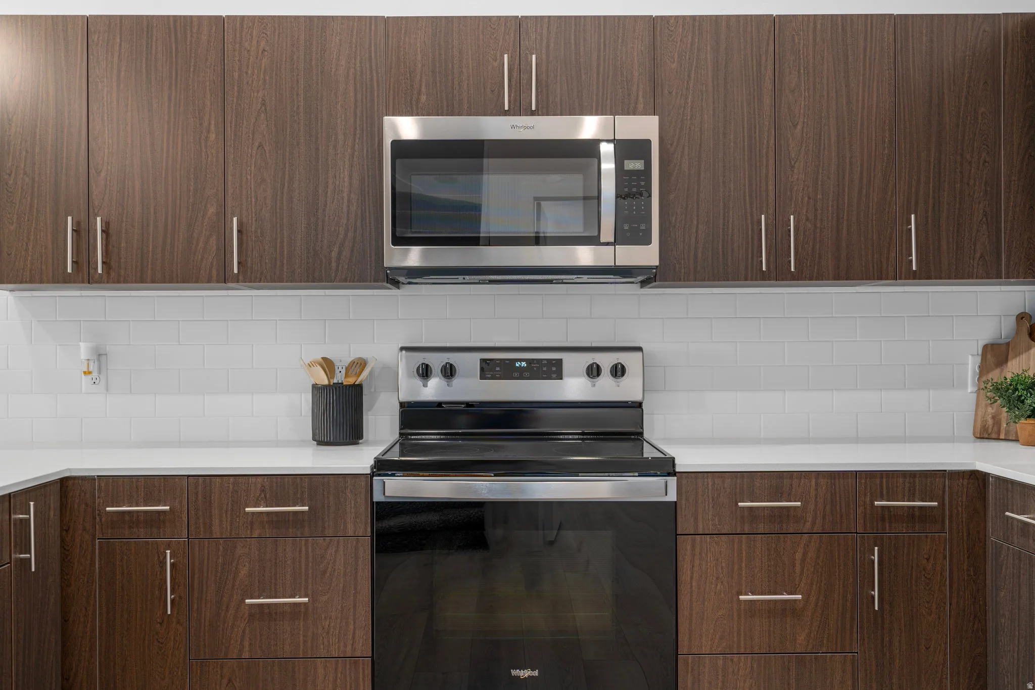 Modern kitchen with dark wood tone cabinets and elevated finishes. *Fridge not included.