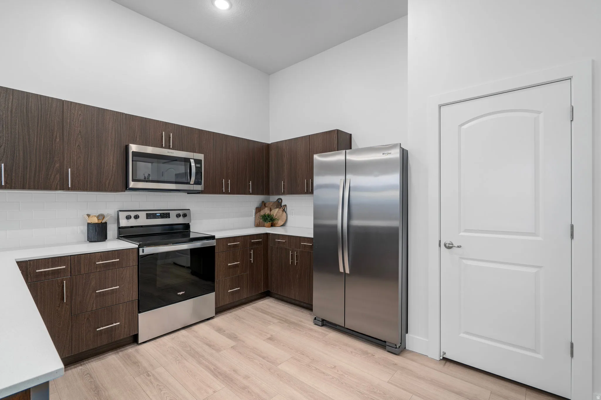 Modern kitchen with dark wood tone cabinets and elevated finishes. *Fridge not included.