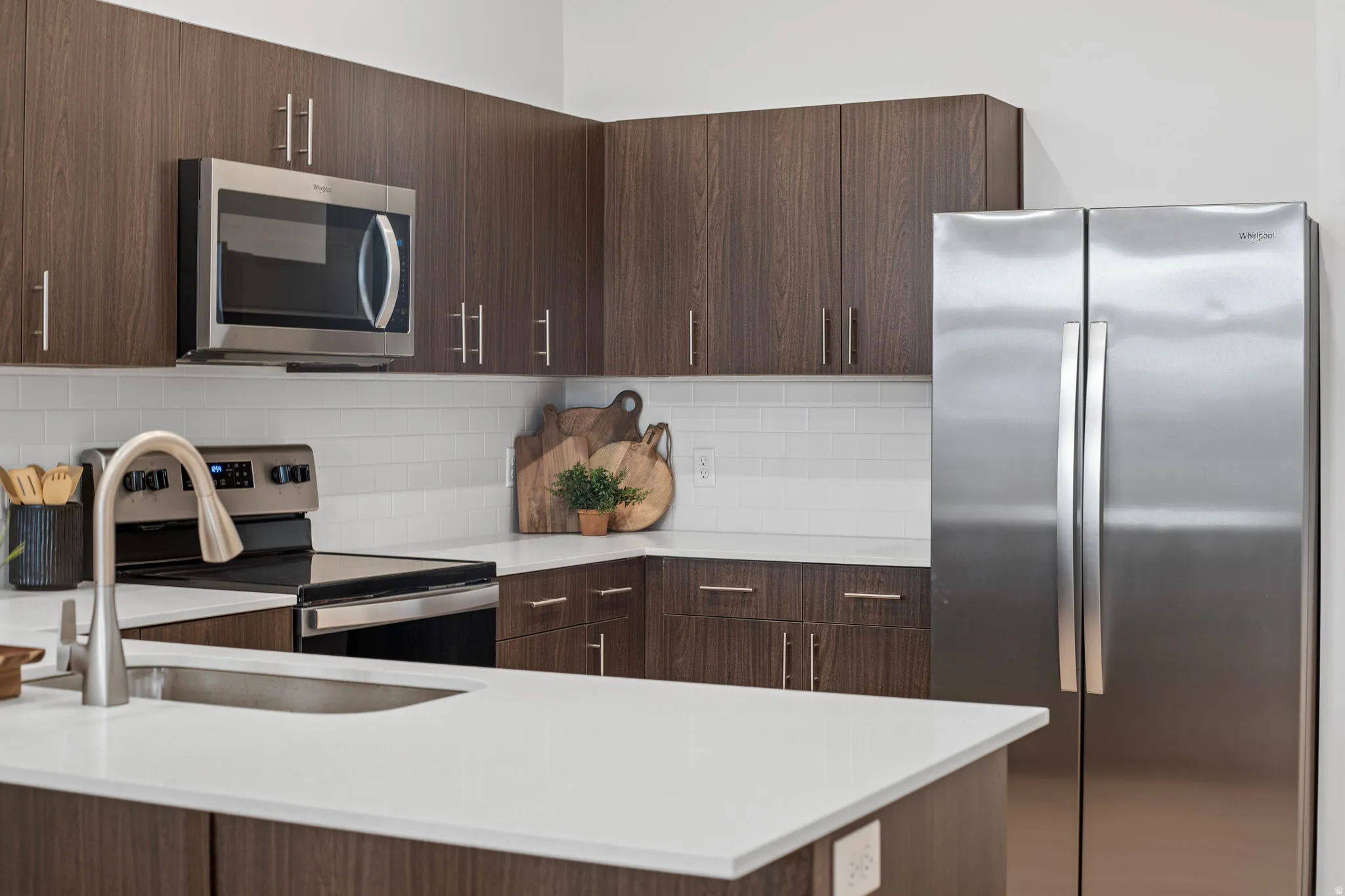 Modern kitchen with dark wood tone cabinets and elevated finishes. *Fridge not included.