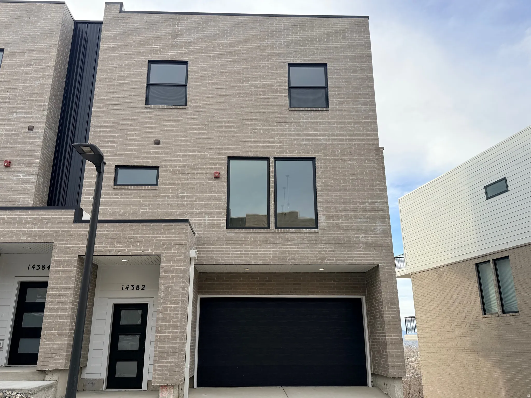 Contemporary house with brick siding and a garage