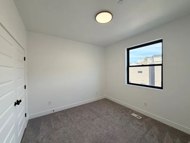 Spare room with baseboards and dark colored carpet