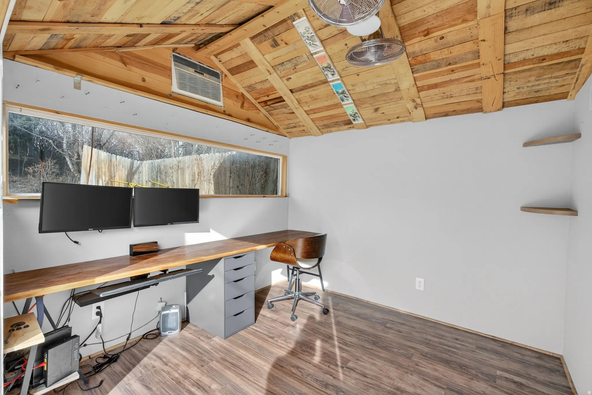 Office with a wooden ceiling with exposed beams and wood finished floors