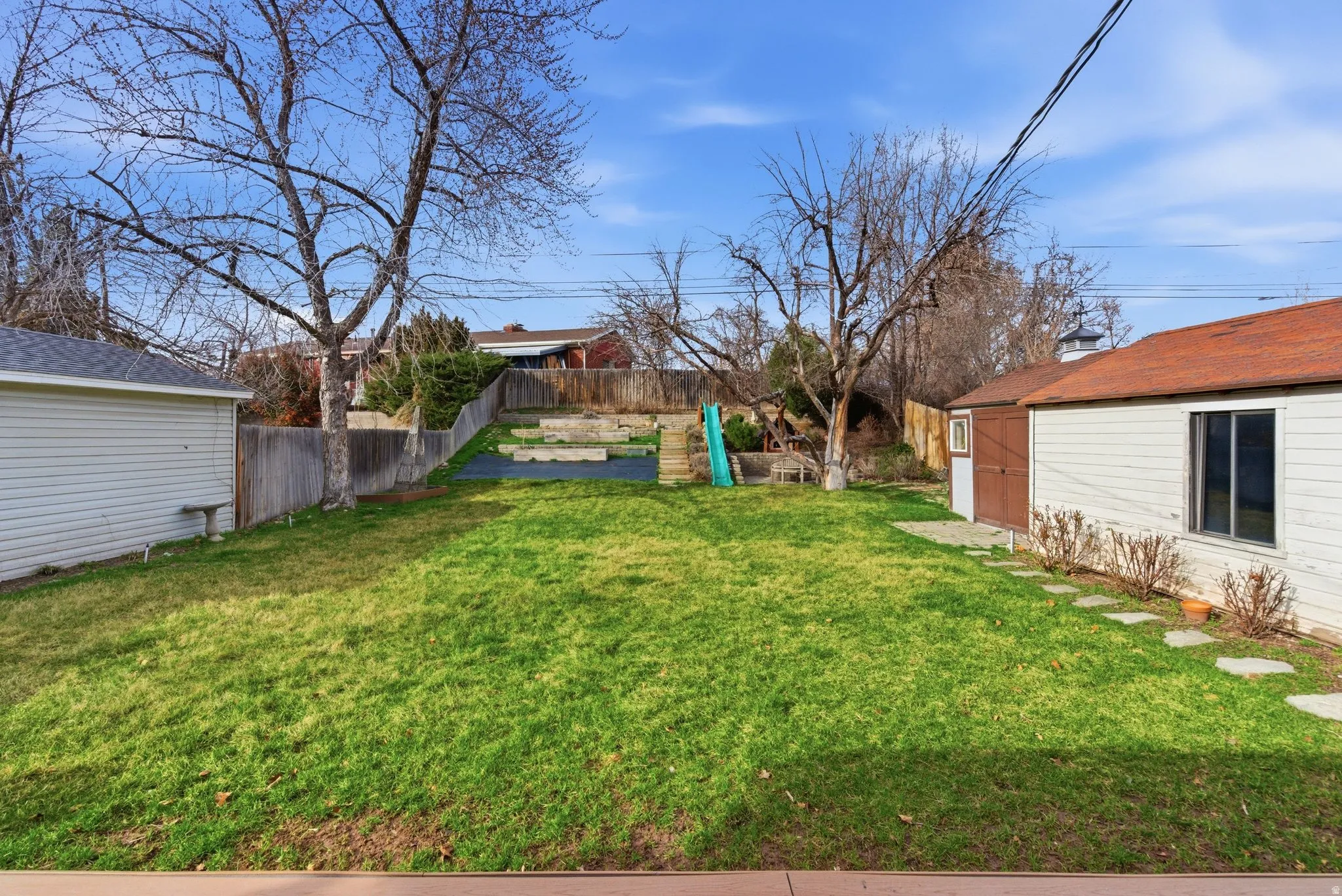 Fenced backyard featuring an outdoor structure