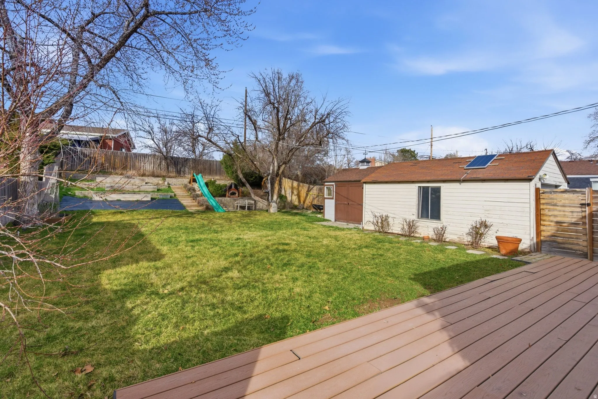 Wooden deck featuring a fenced backyard and an outdoor structure