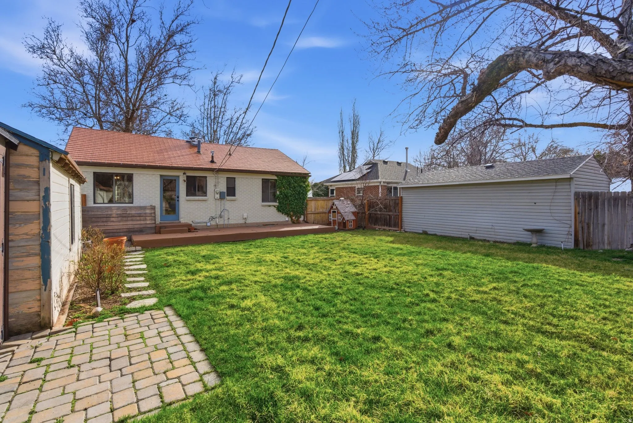 Rear view of property featuring a fenced backyard, a deck, and brick siding