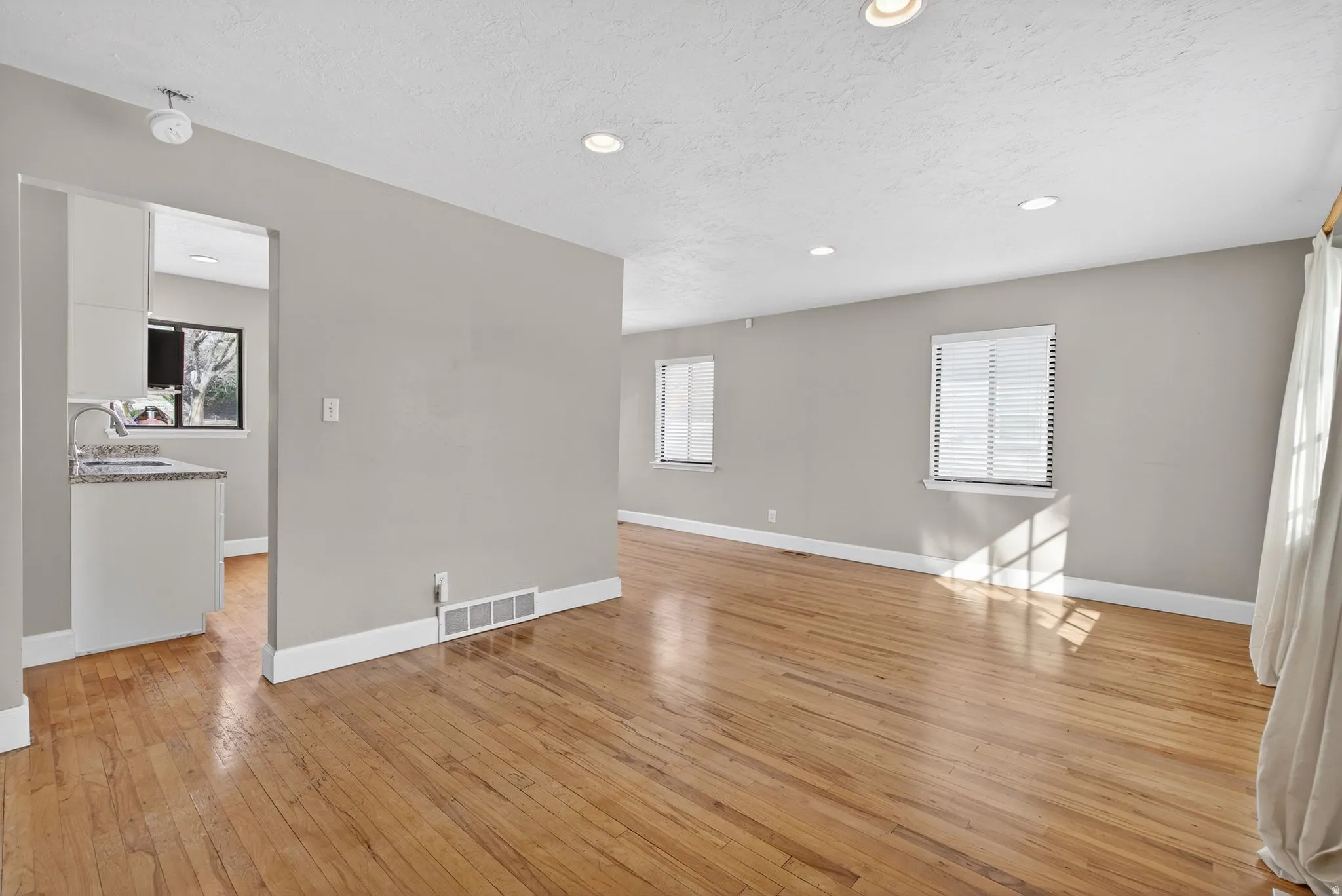 Unfurnished room featuring light wood finished floors, recessed lighting, and a textured ceiling