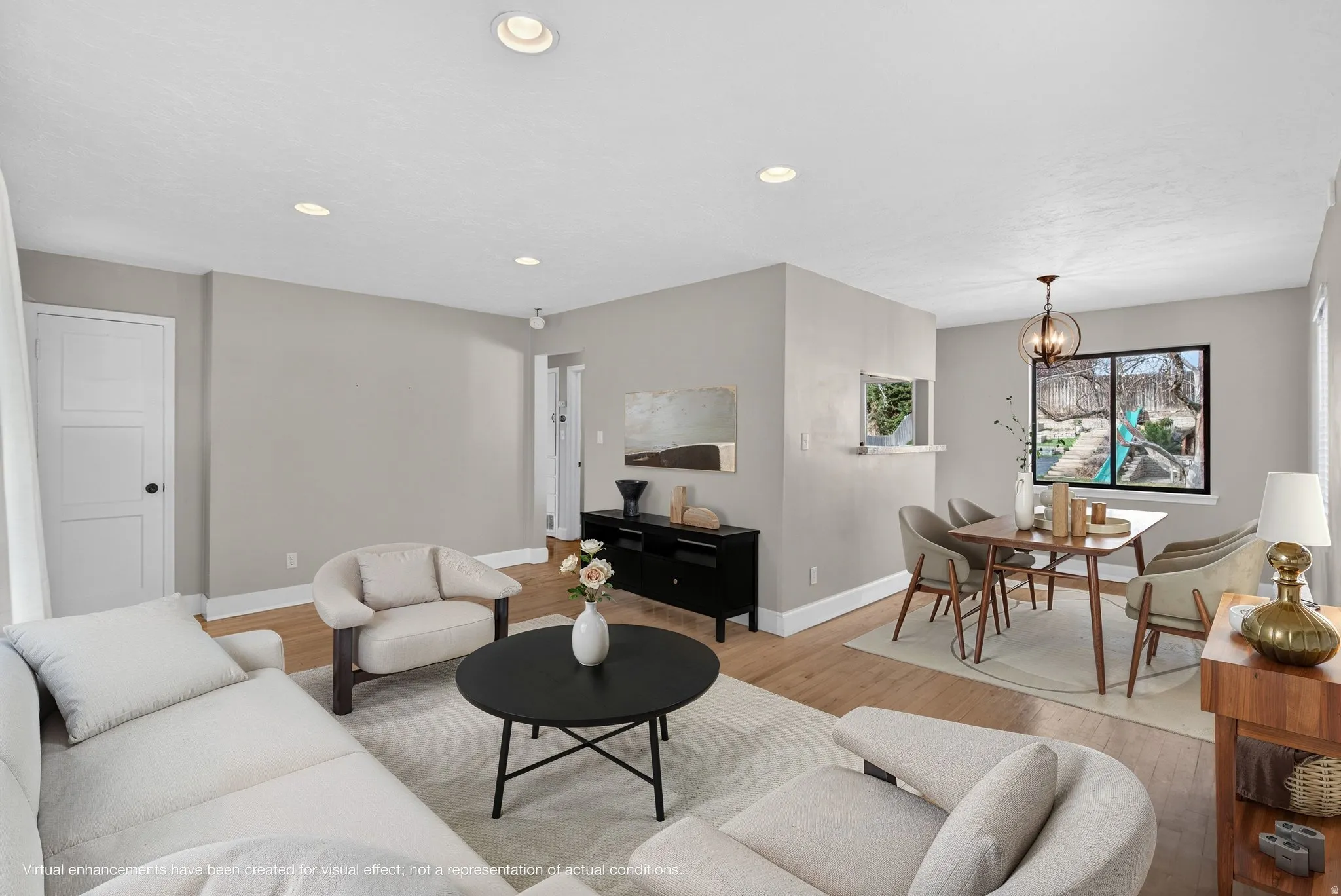 Living room featuring light wood-style floors and suspended lighting