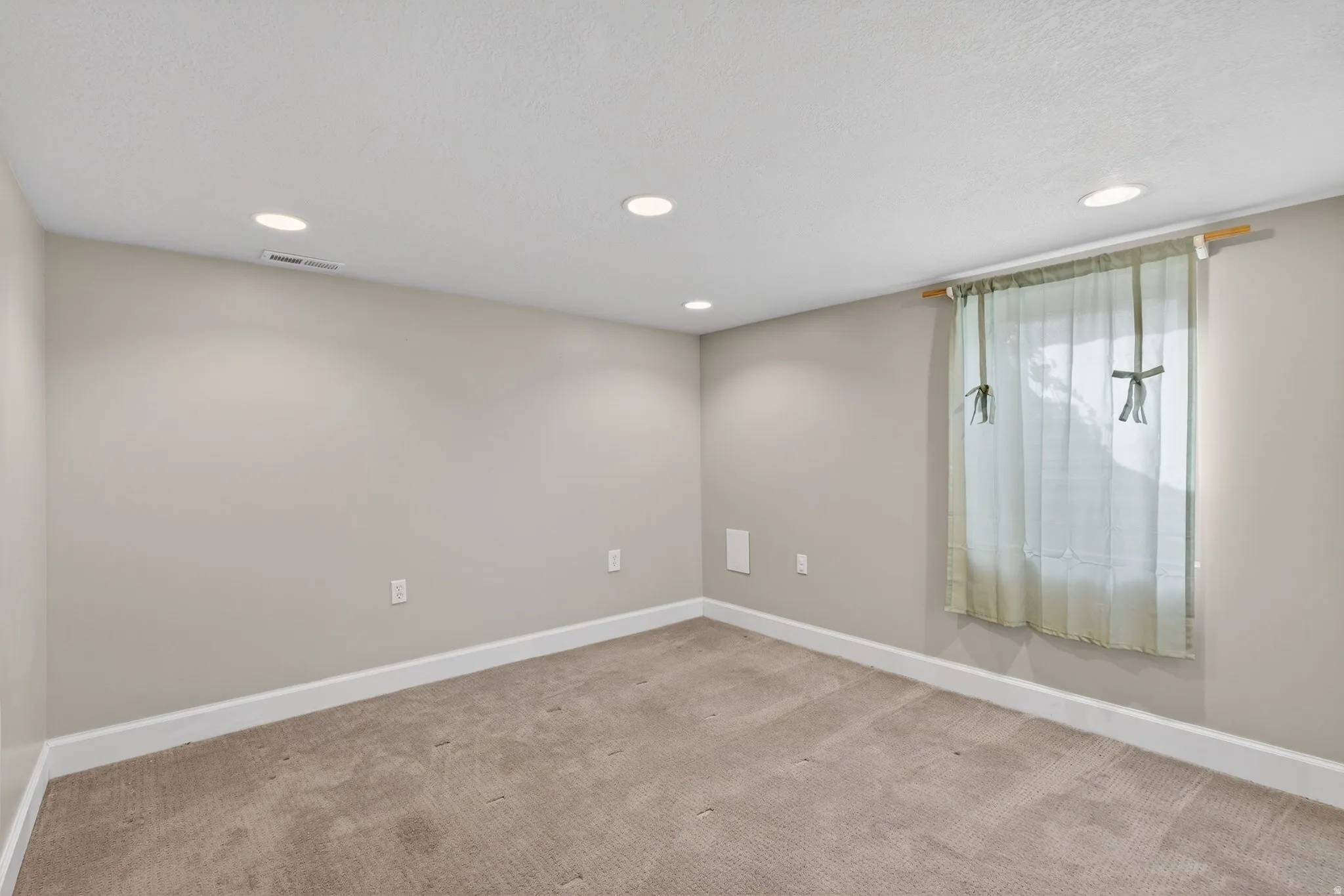 Empty room featuring recessed lighting and light colored carpet