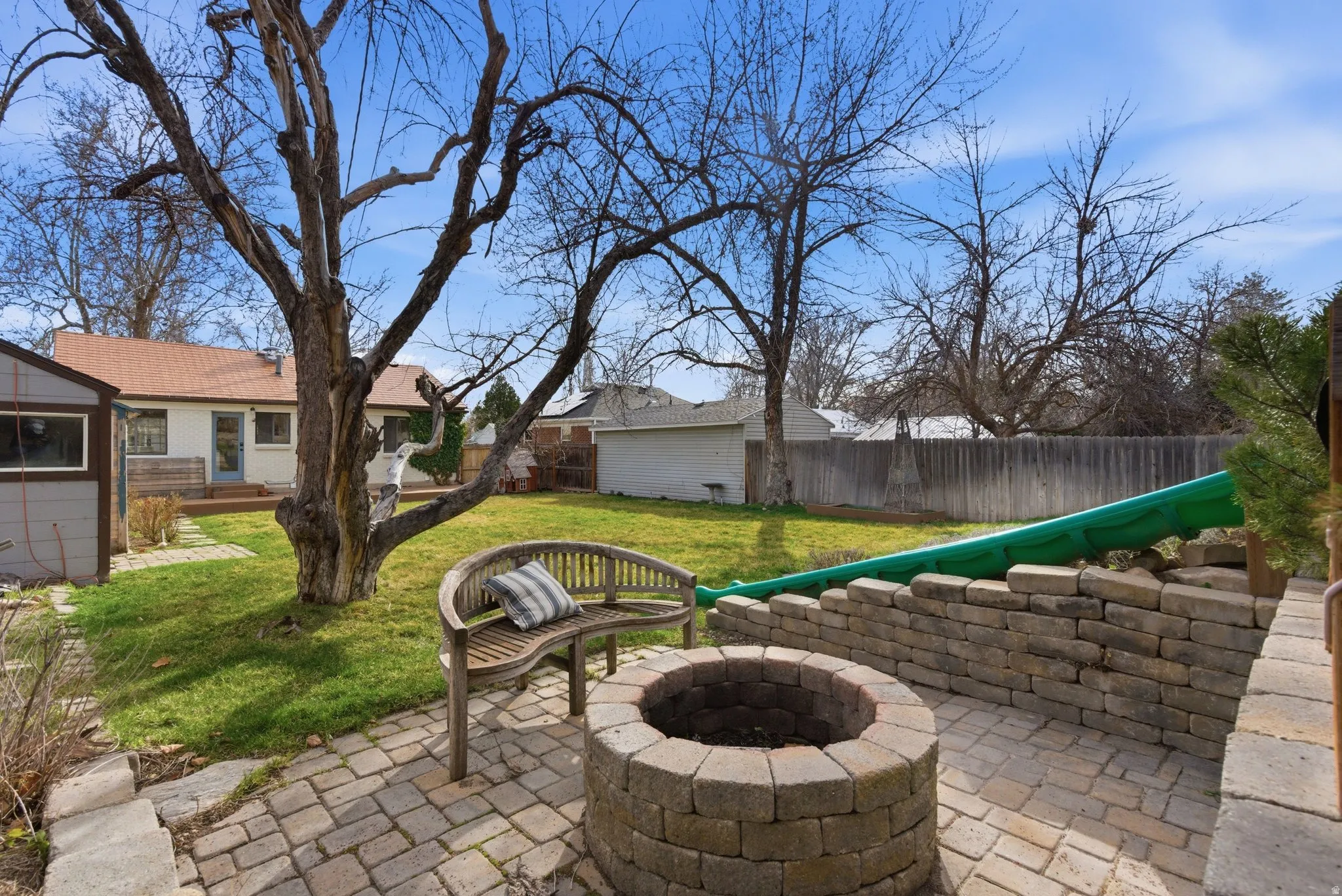 Fenced backyard featuring a patio area and a fire pit