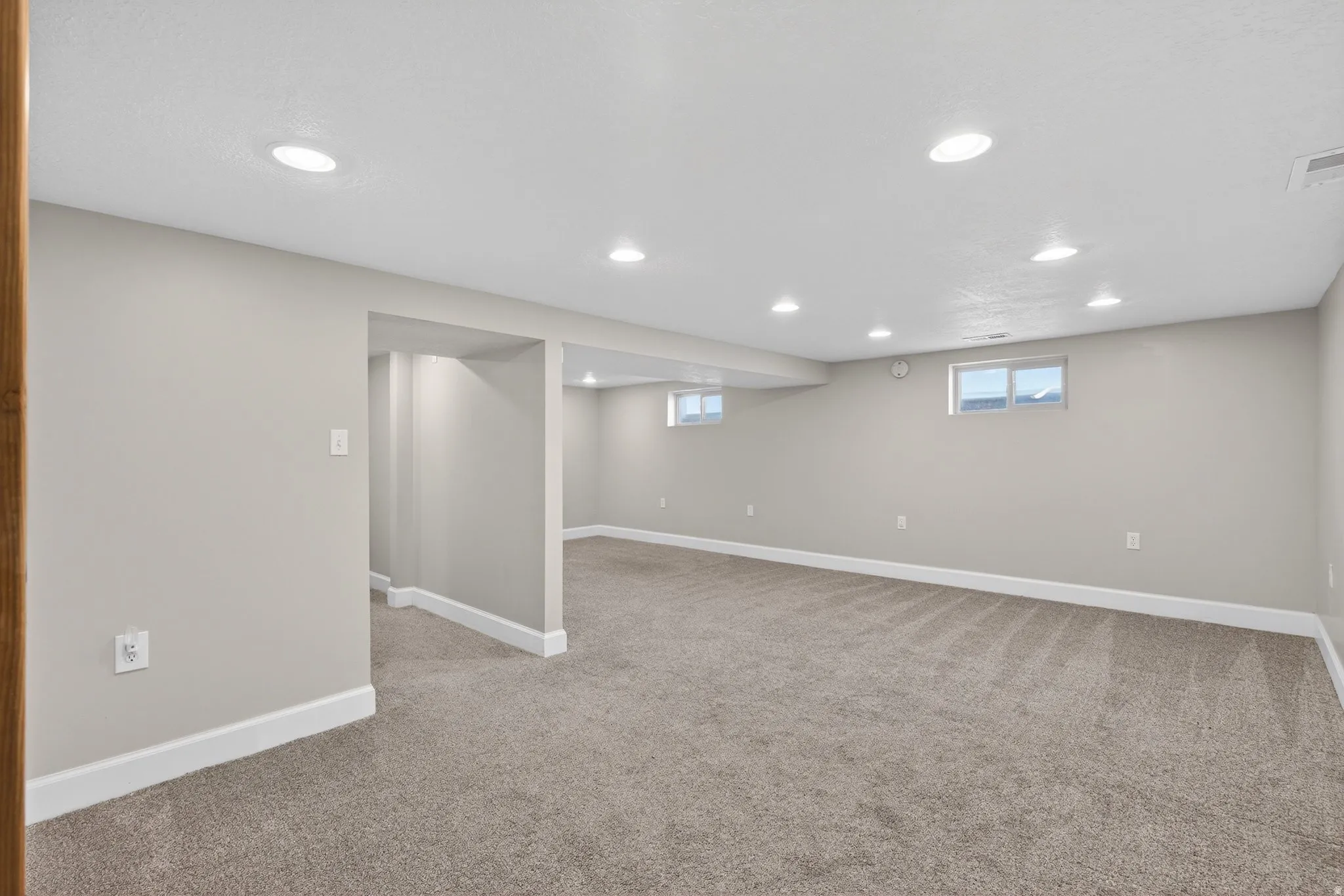 Basement with recessed lighting and light colored carpet