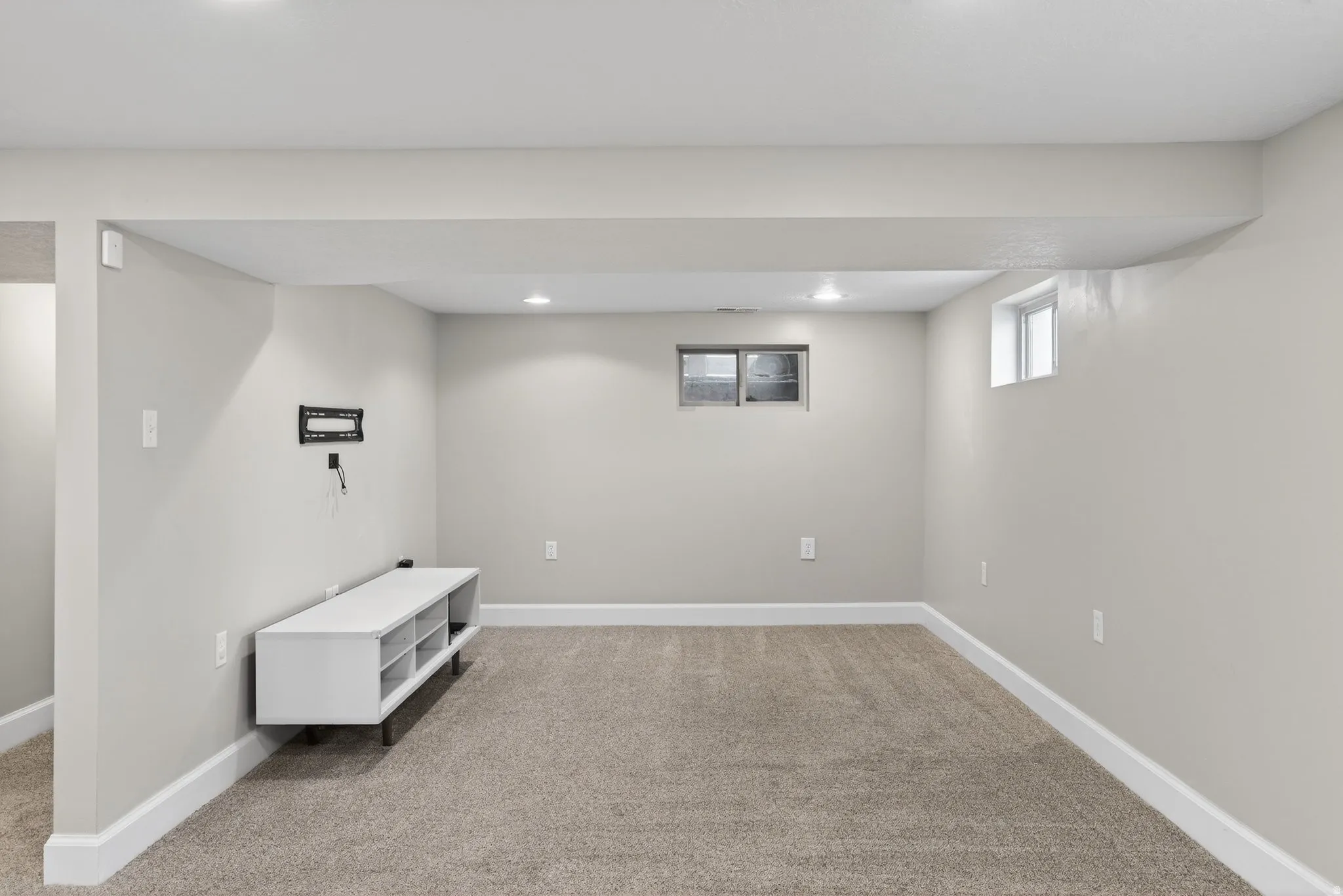 Basement with light colored carpet and recessed lighting