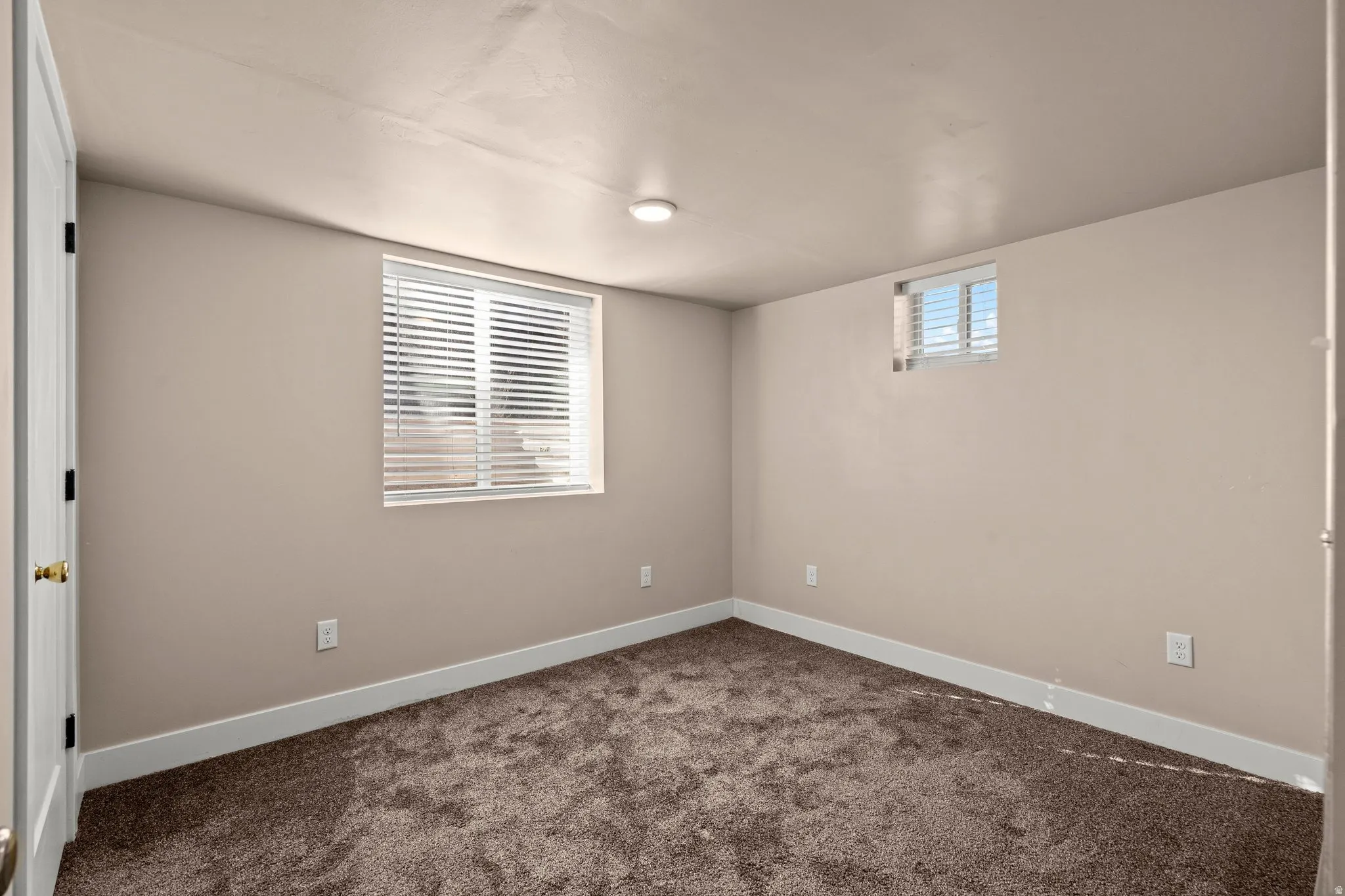 Below grade area with dark carpet and baseboards