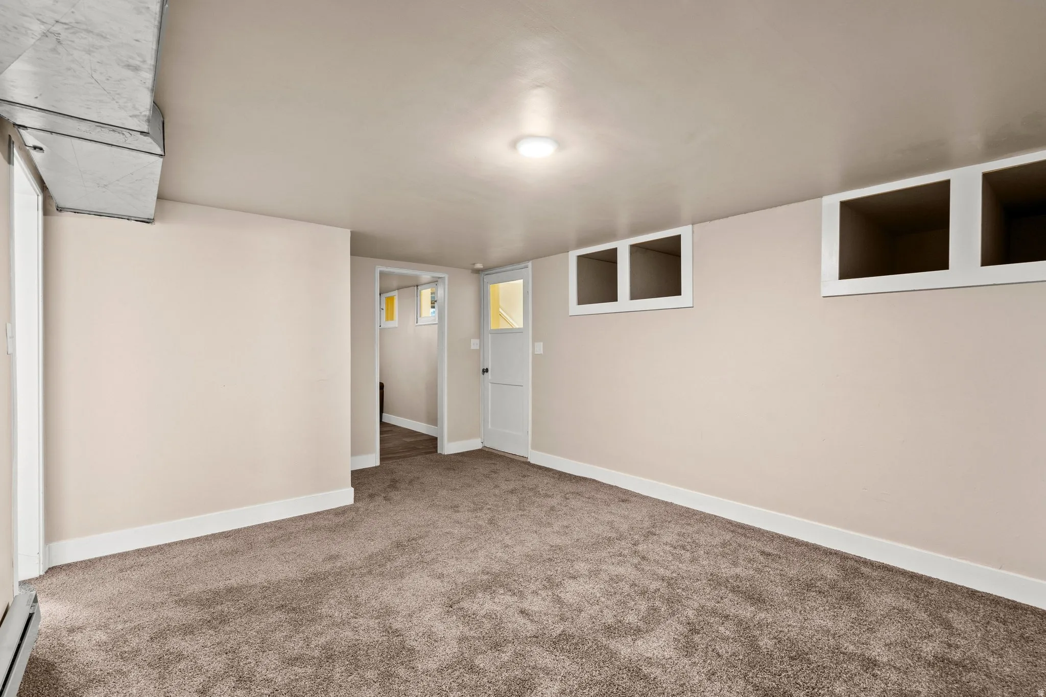 Finished below grade area with carpet floors and baseboard heating