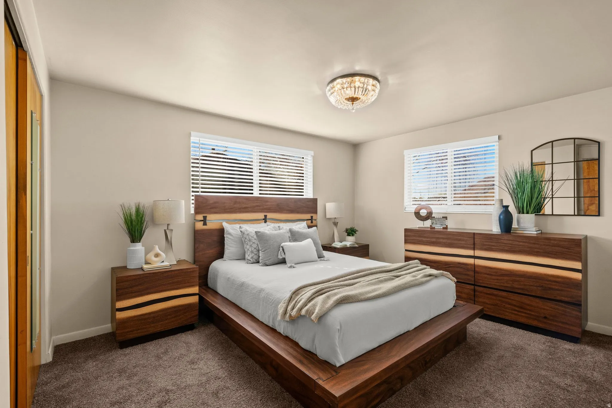 Bedroom with dark colored carpet and multiple windows