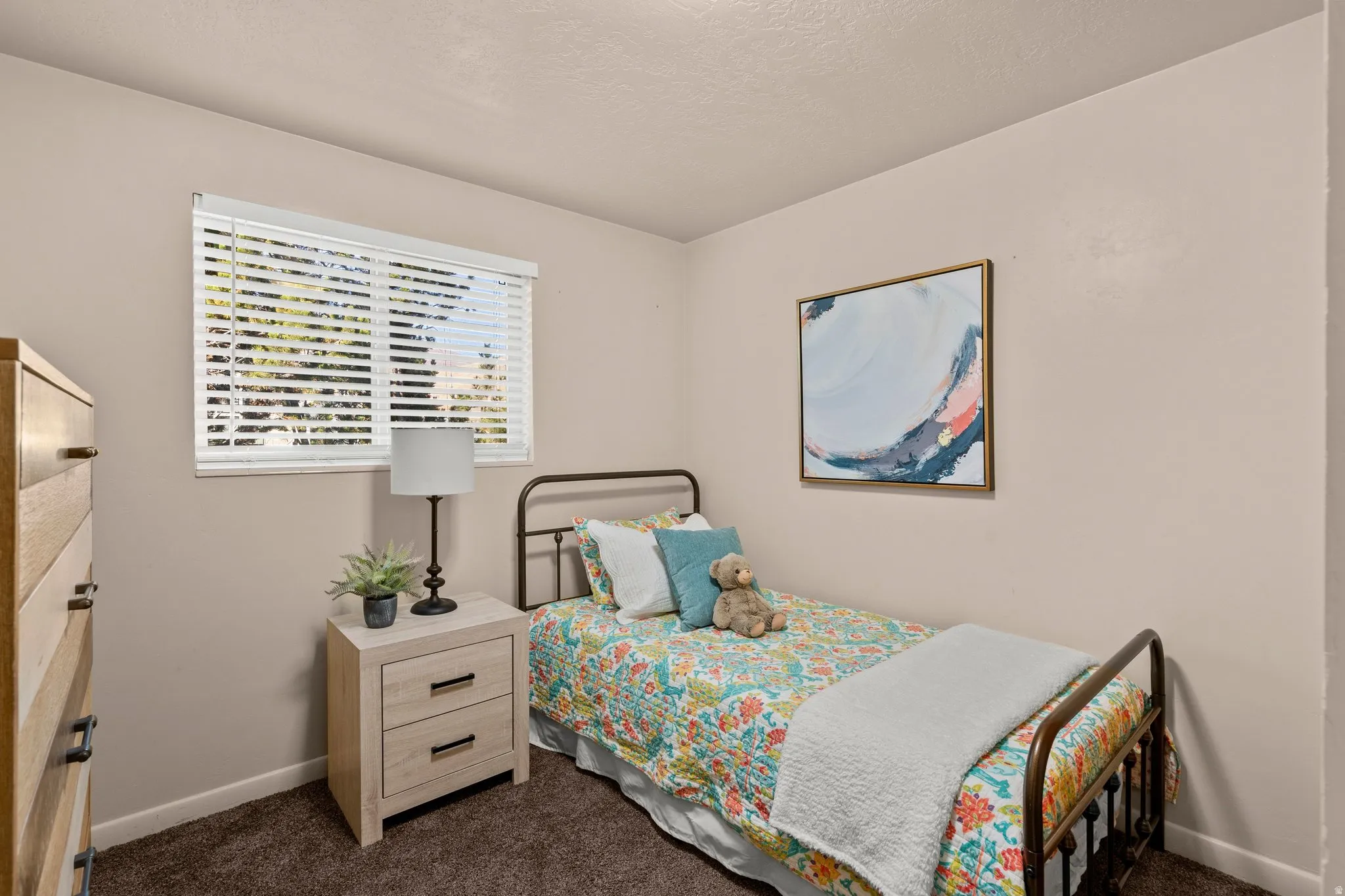Bedroom featuring dark carpet and a textured ceiling