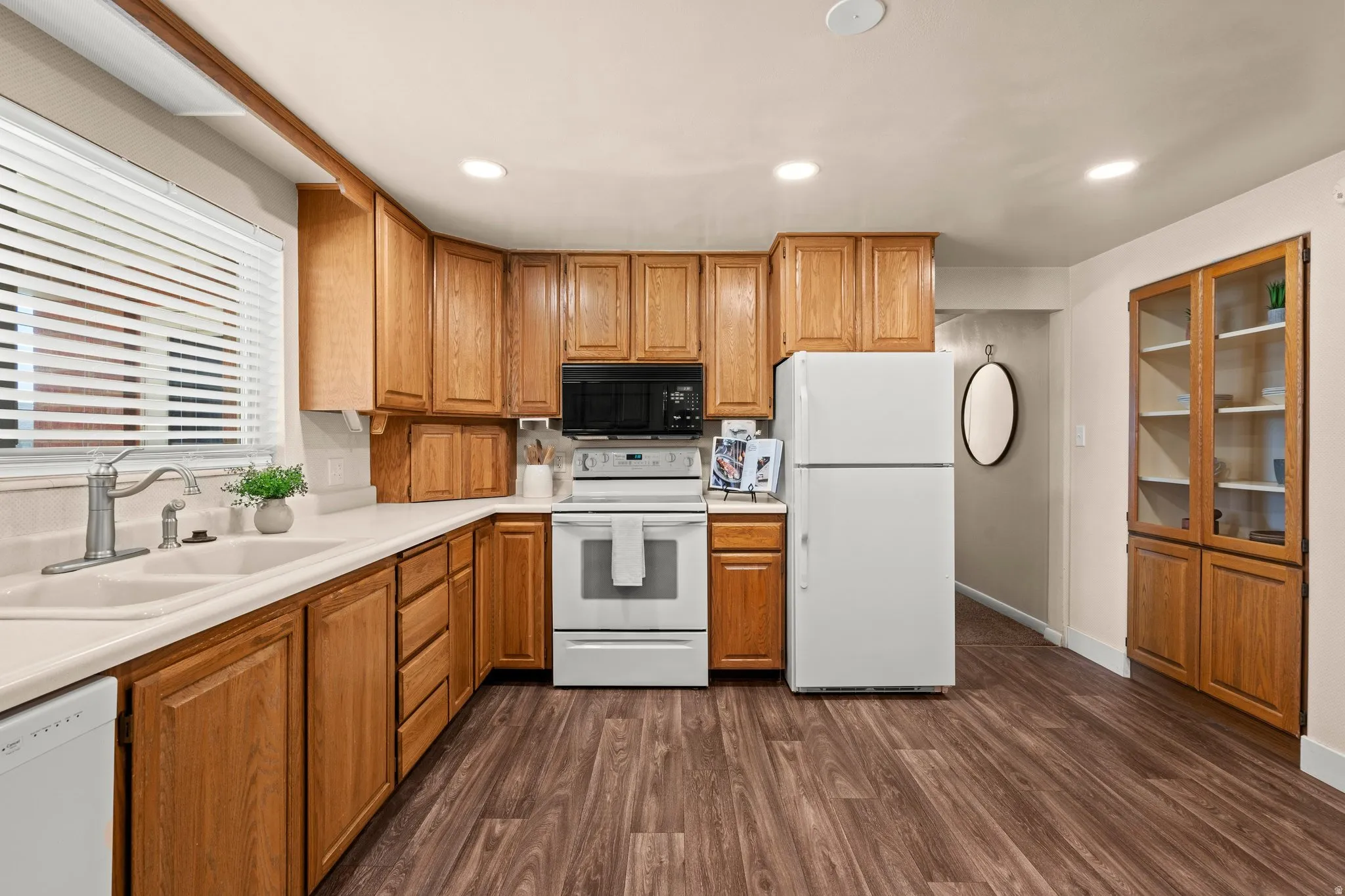 Kitchen featuring white appliances, light countertops, dark wood-style flooring, recessed lighting, and wood finish cabinets