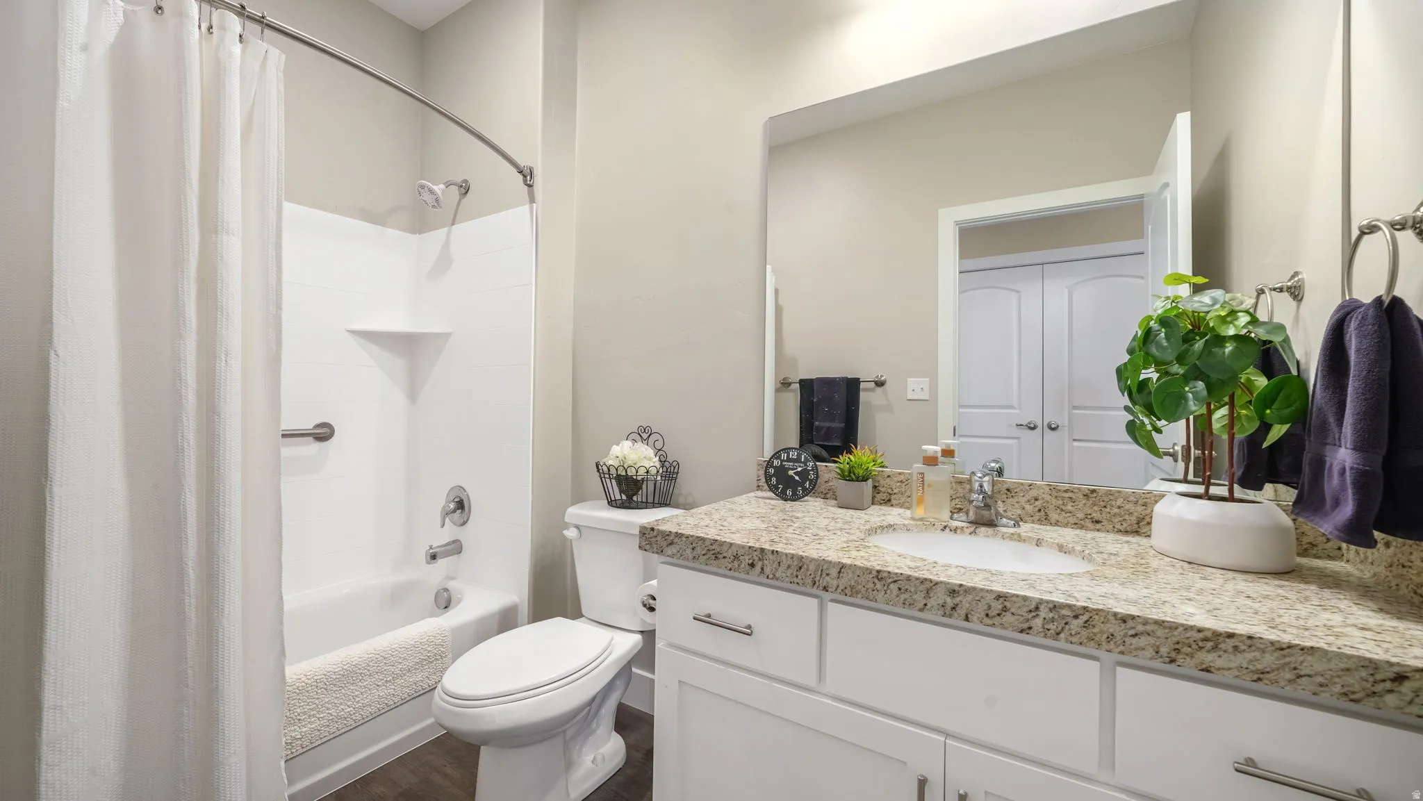 Hallway bathroom featuring vanity, shower/bath combo