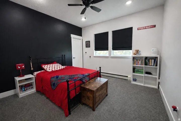 Bedroom with a baseboard radiator, carpet, and ceiling fan