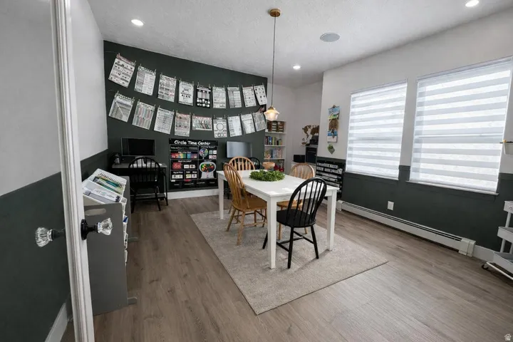 Dining room with a baseboard heating unit, recessed lighting, light wood finished floors, and a textured ceiling