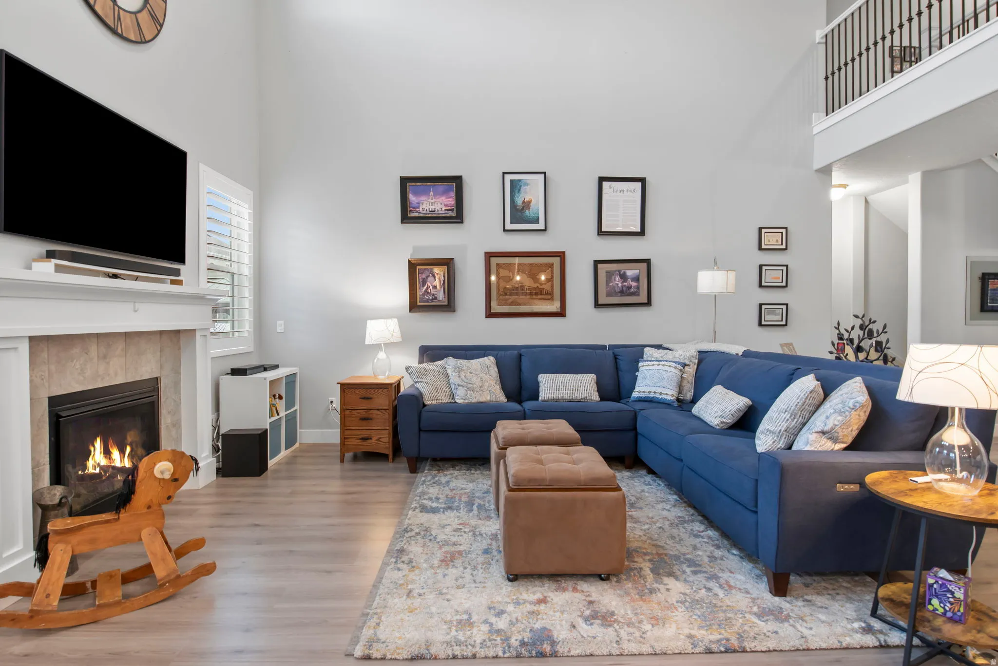 Living area with a fireplace, a high ceiling, and wood finished floors